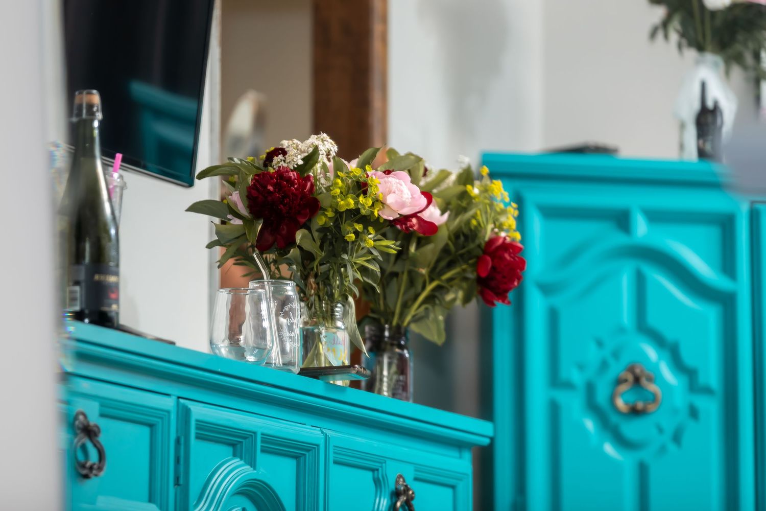 Elegant row of turquoise vanity cabinets with gold accents in a bridal preparation room.