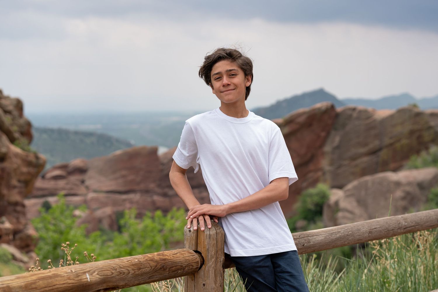 Casual outdoor family photos taken at Red Rocks with mountain landscape backdrop.