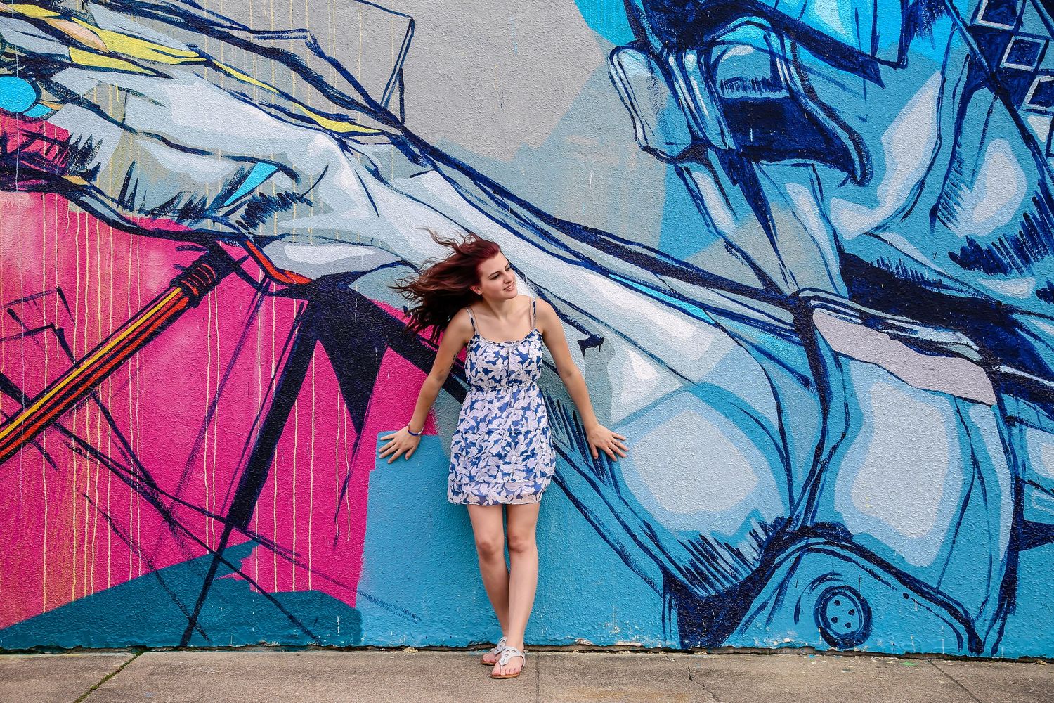Dynamic poses captured against urban street art featuring blue and pink graffiti murals.