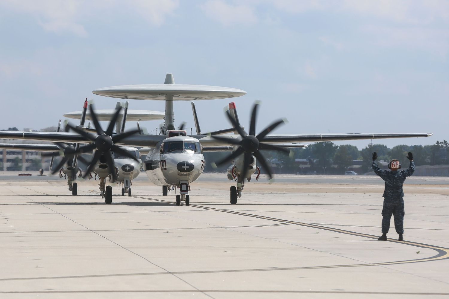 Military aircraft parked on runway during homecoming ceremony.