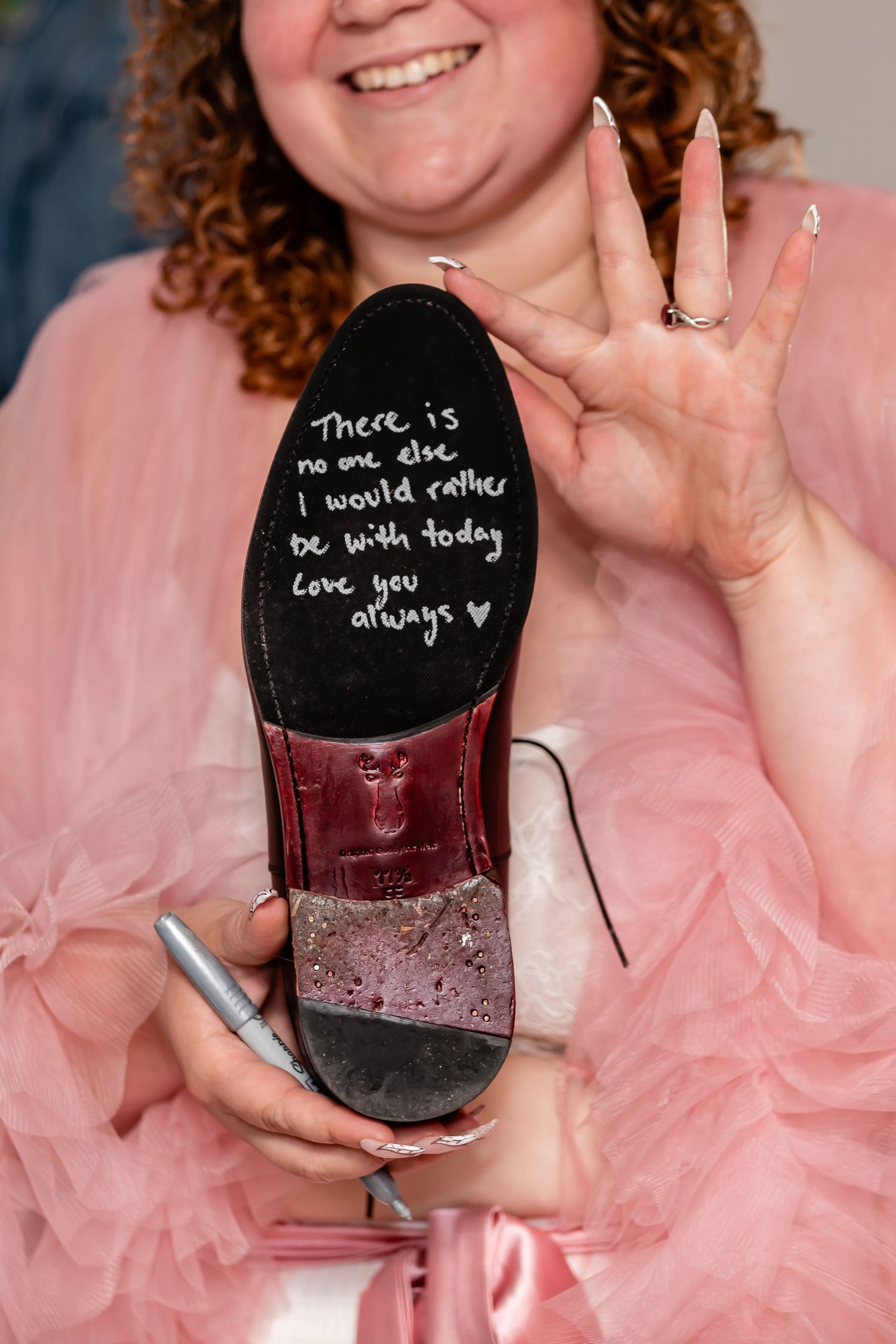 Someone in pink tulle holding a wine glass with writing on it.