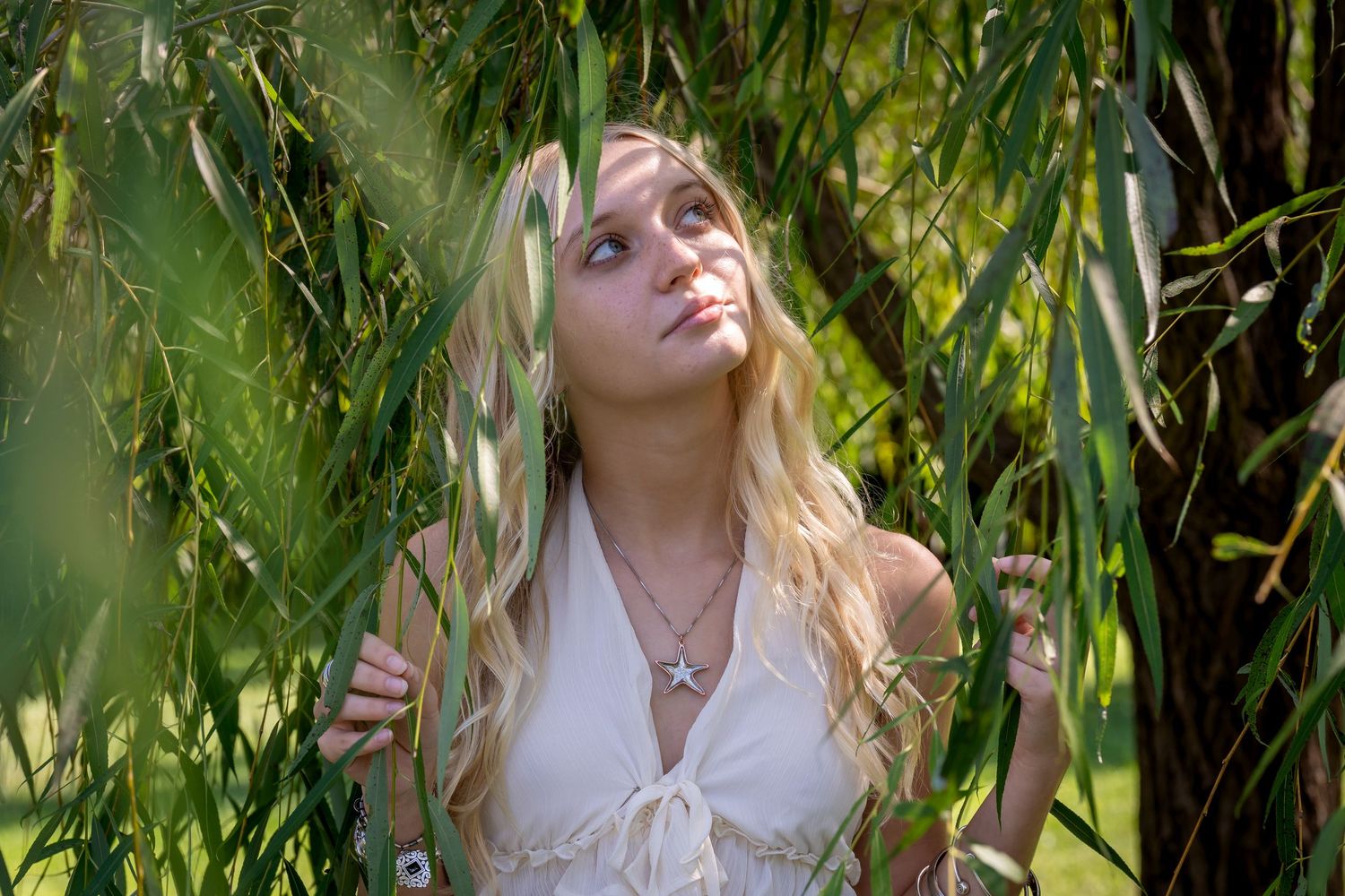 Portrait series with lush green foliage background and white summer dress.