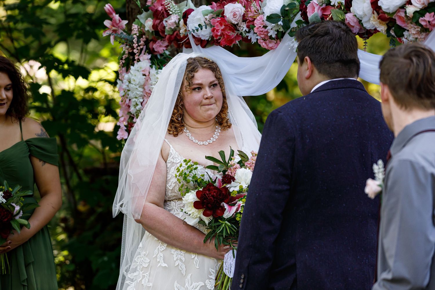 Wedding ceremony in a garden setting with beautiful floral arrangements and decorative arch.