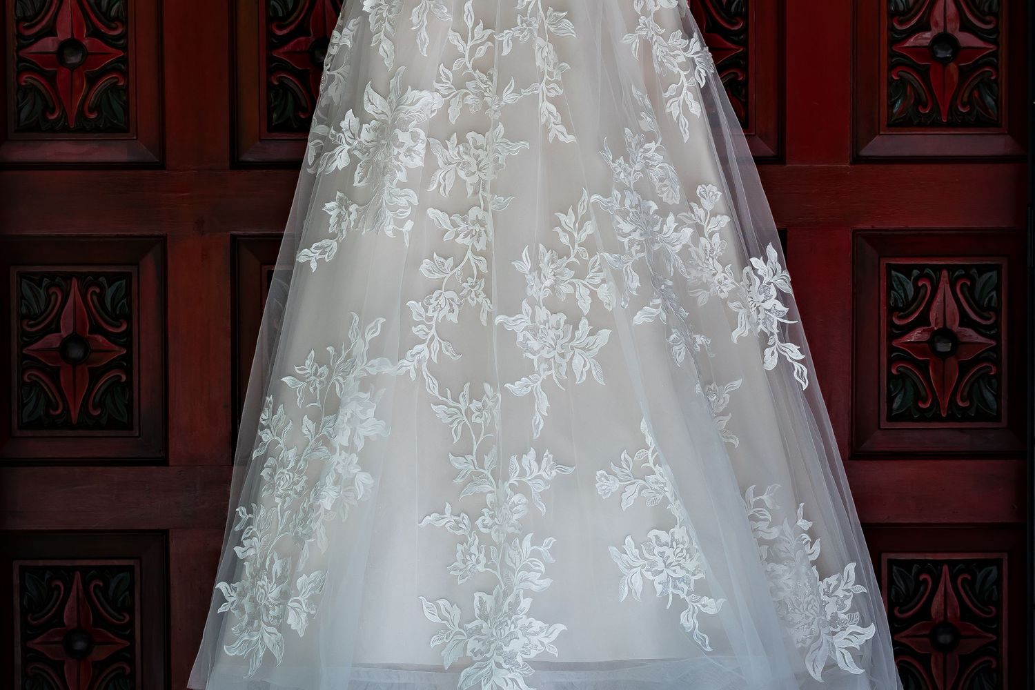 White lace detailing on an elegant wedding dress displays intricate floral patterns.