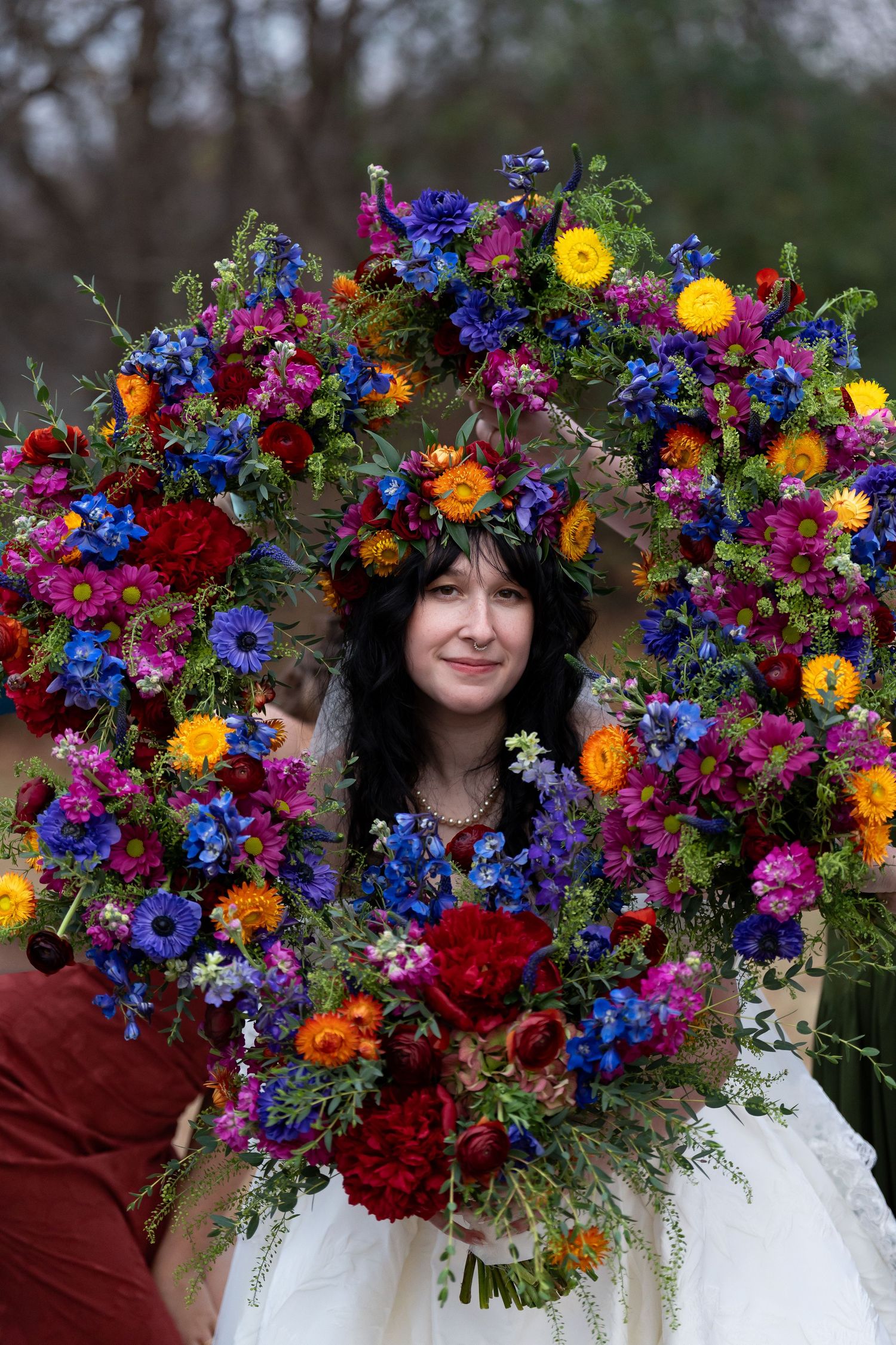 Vibrant floral crown with blue, purple, and orange wildflowers creates stunning wedding accessory.