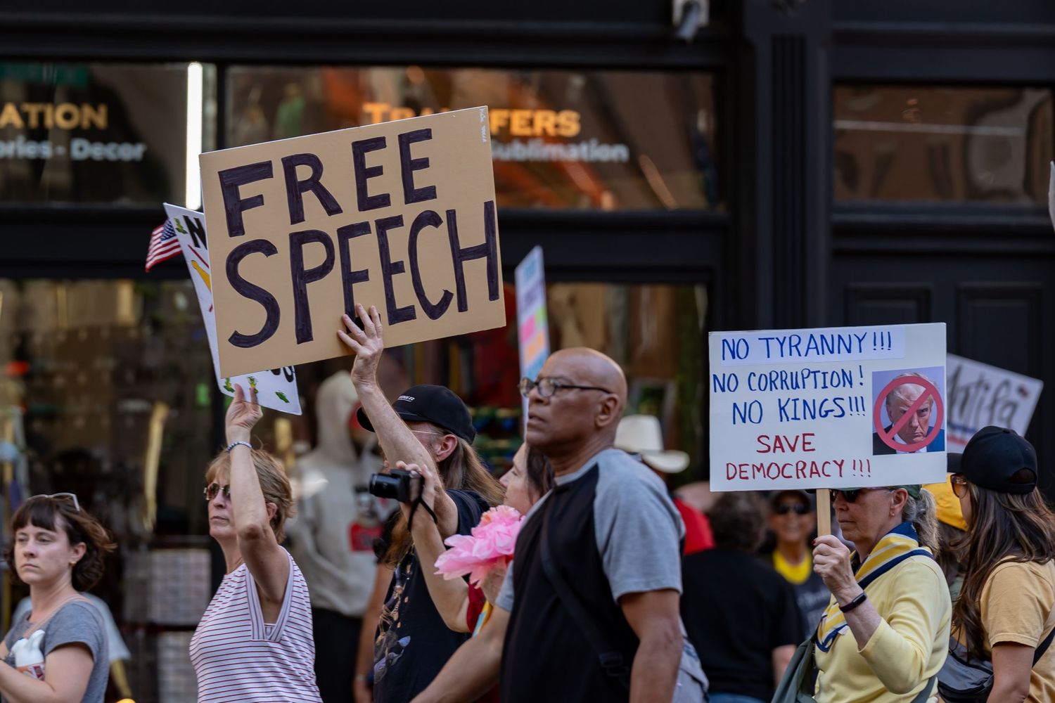 Demonstrators holding Free Speech and other protest signs during street rally.
