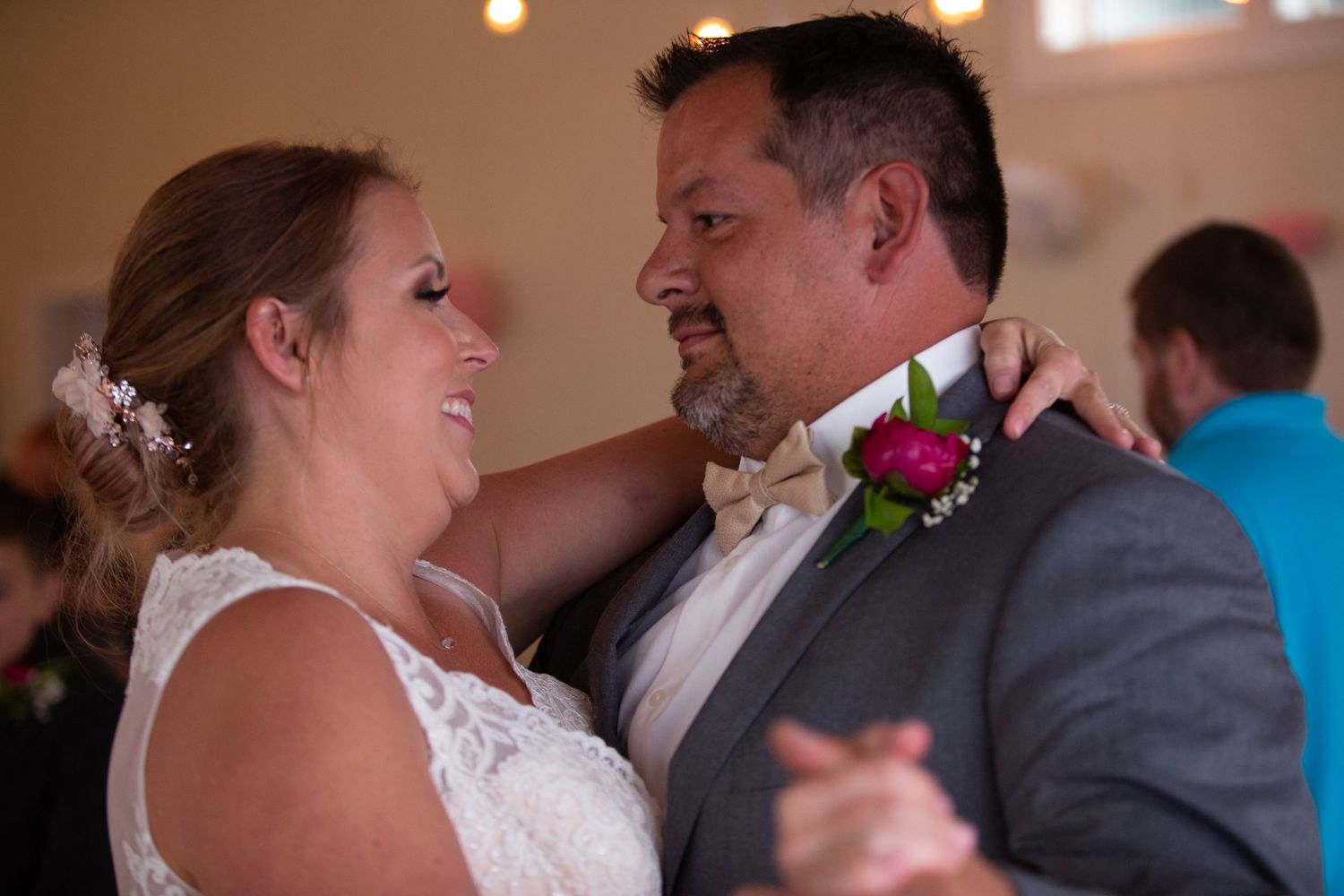 Couples dancing together at a wedding reception in an indoor venue with warm lighting.