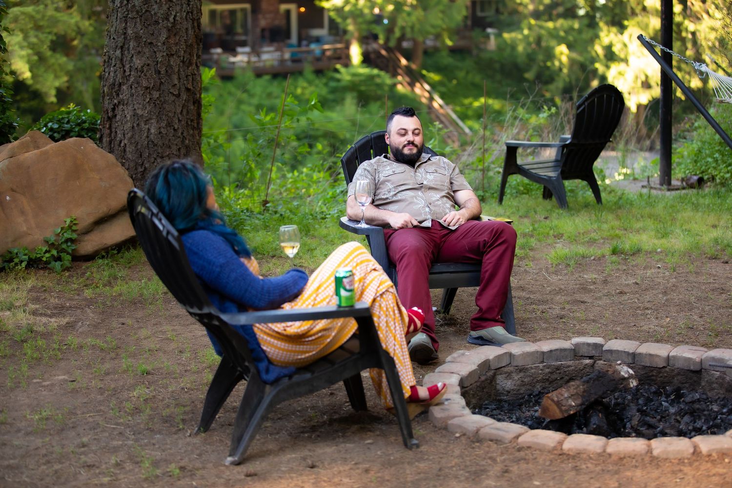 Wedding guests relax in outdoor seating around a fire pit during reception festivities.