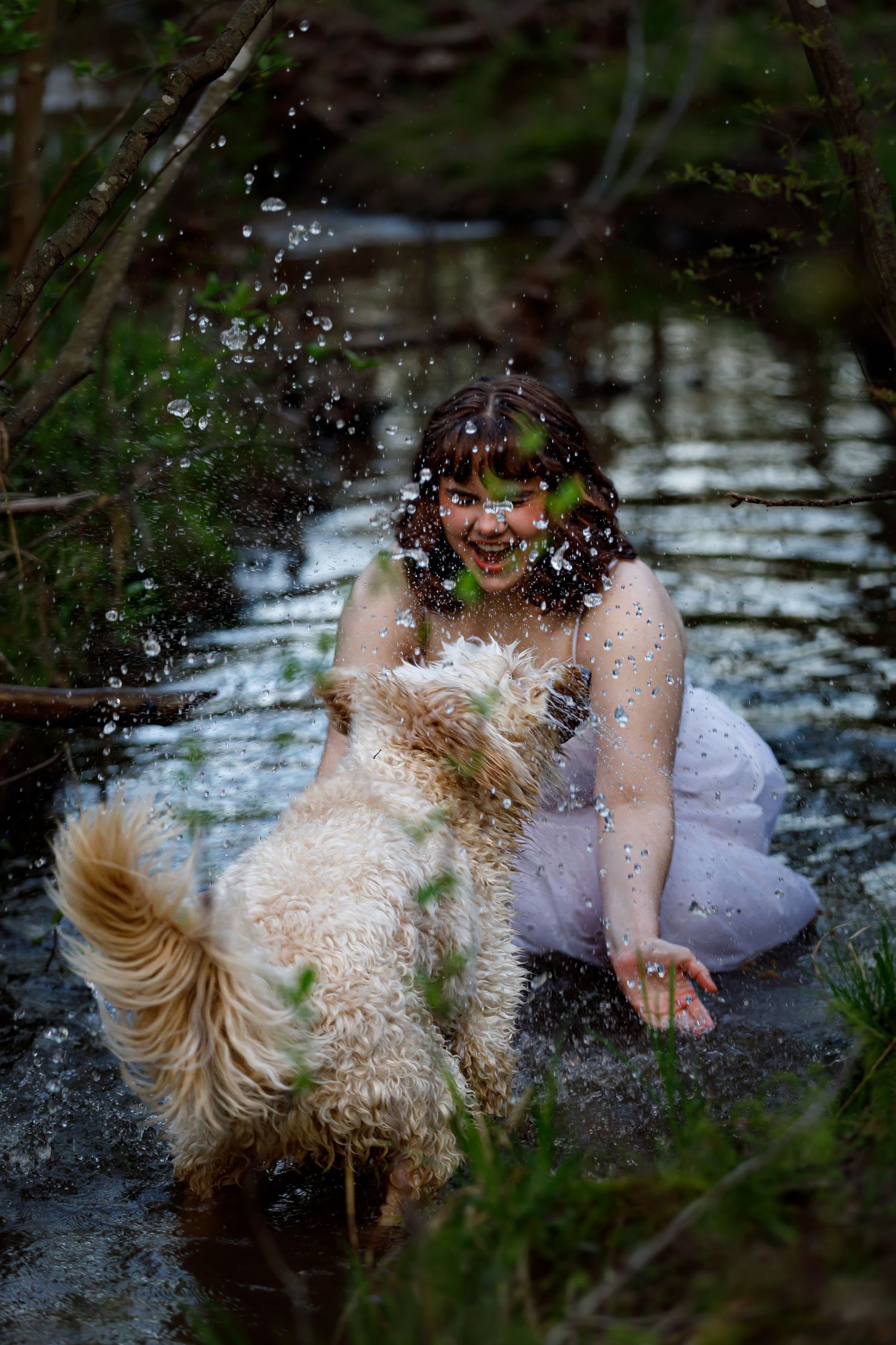 Splashing water creates dramatic effect during an artistic photoshoot in a woodland pond.