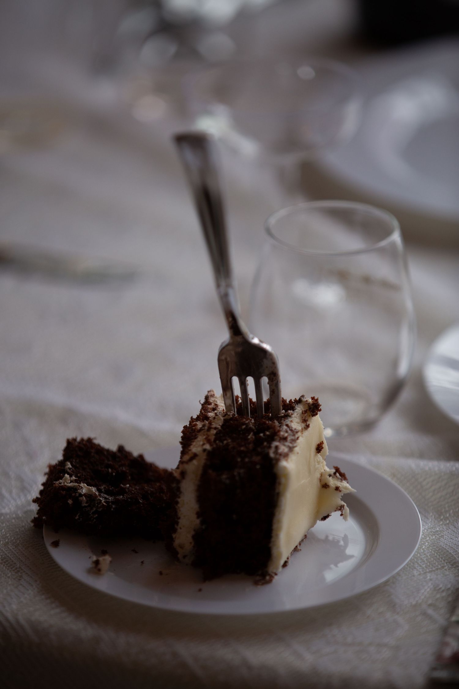 Progressive sequence of a chocolate cake slice being eaten on a white plate with a silver fork.
