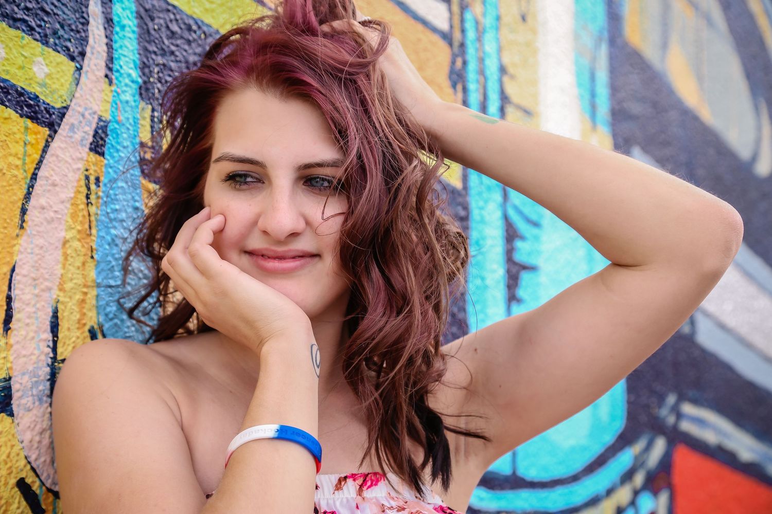 Artistic portrait series against a bright blue and yellow graffiti wall background.