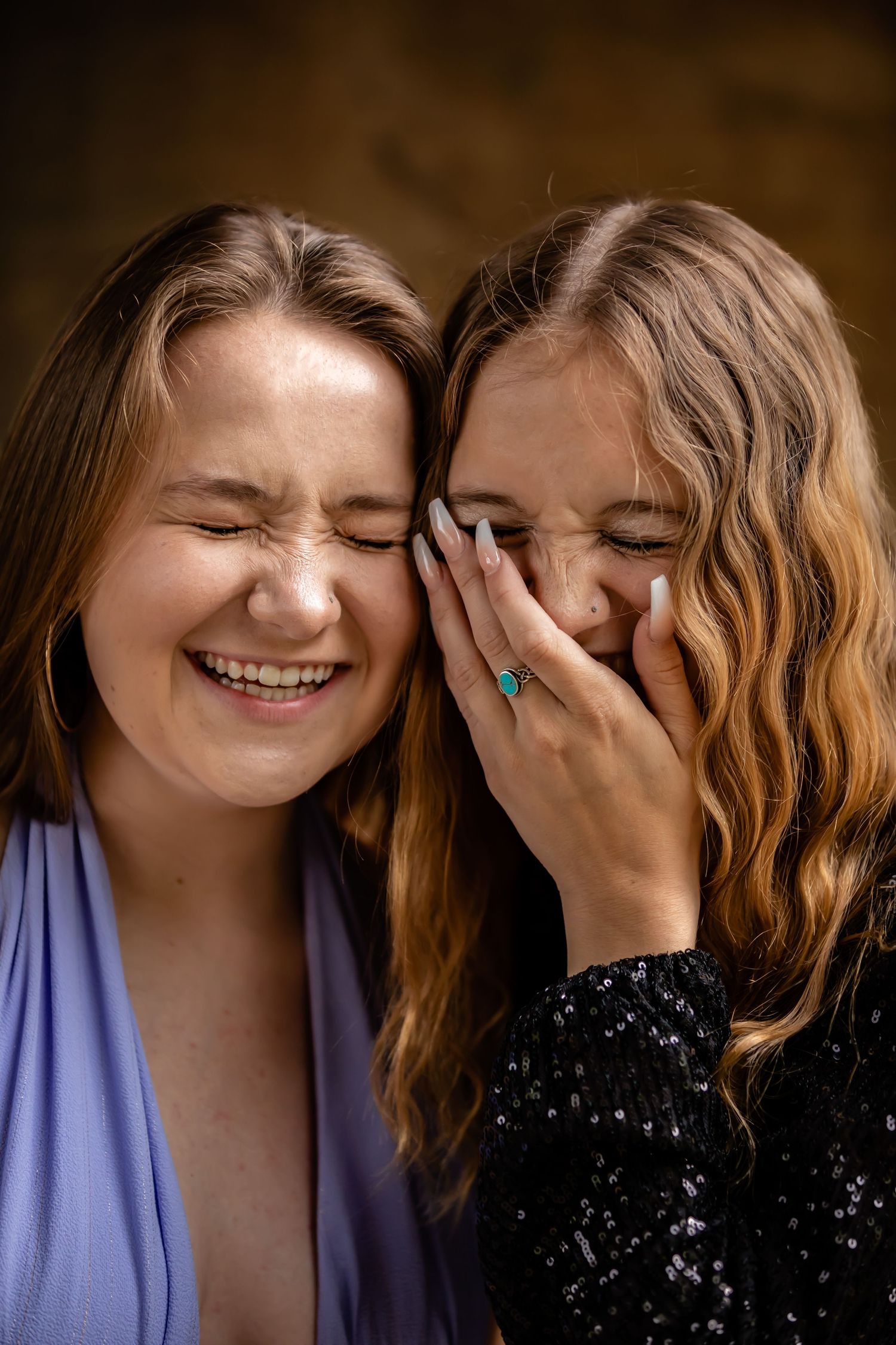 Two people sharing joyful laughter together against a dark background.