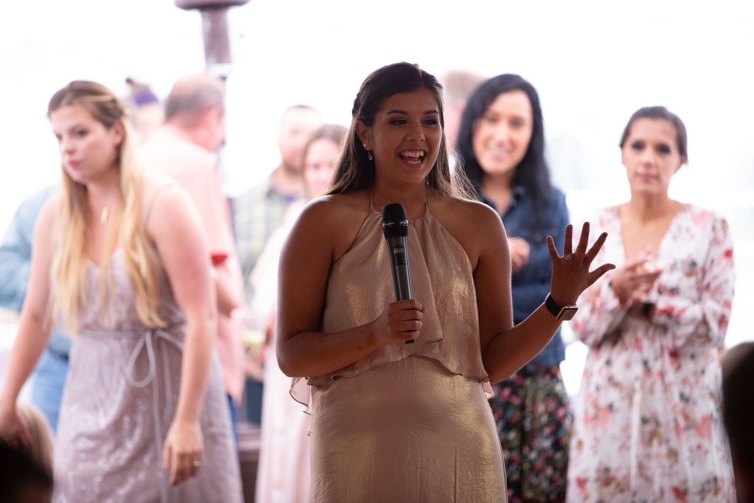 Wedding reception speech being given by someone in beige dress.