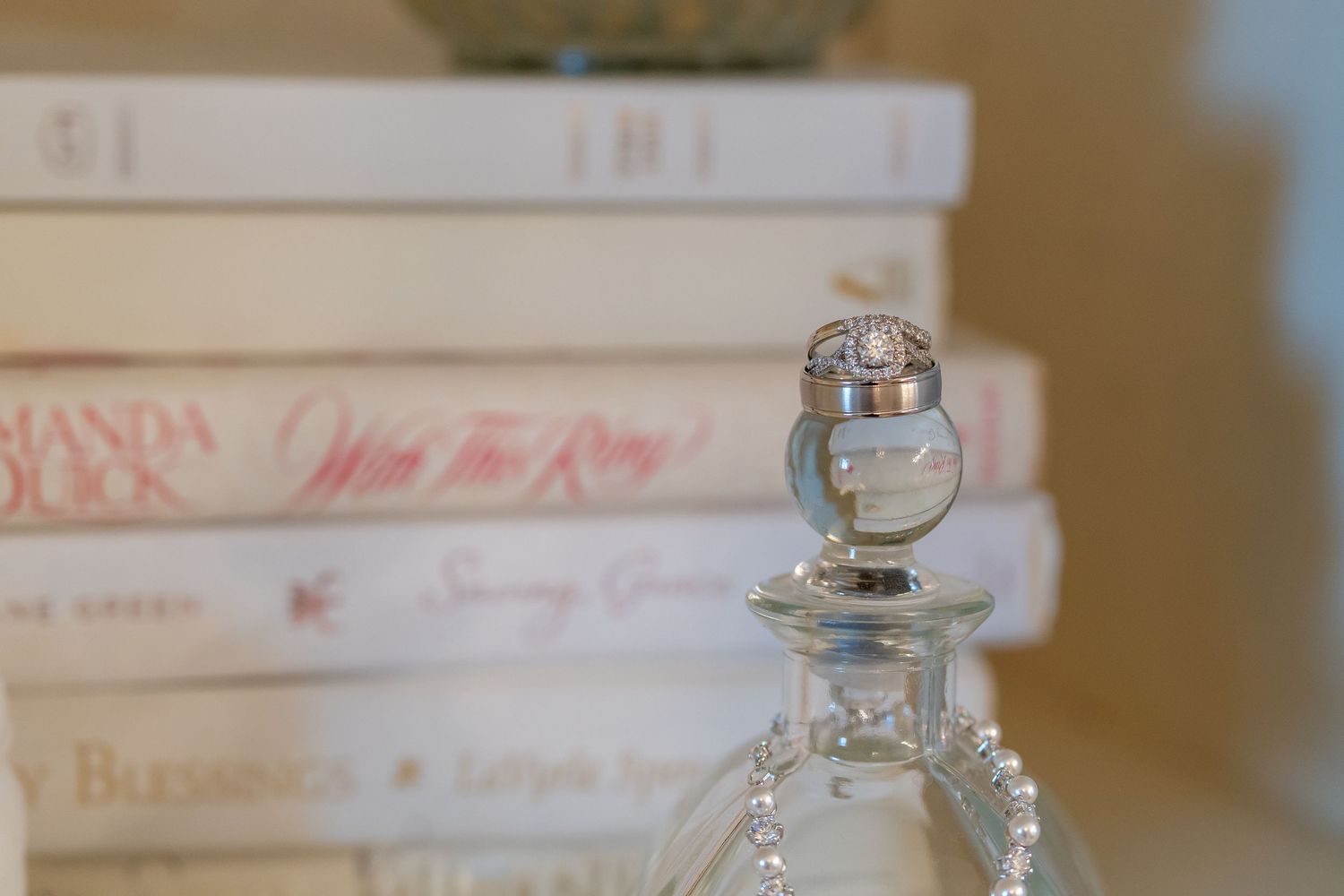Elegant crystal perfume bottle displayed against a backdrop of vintage books.