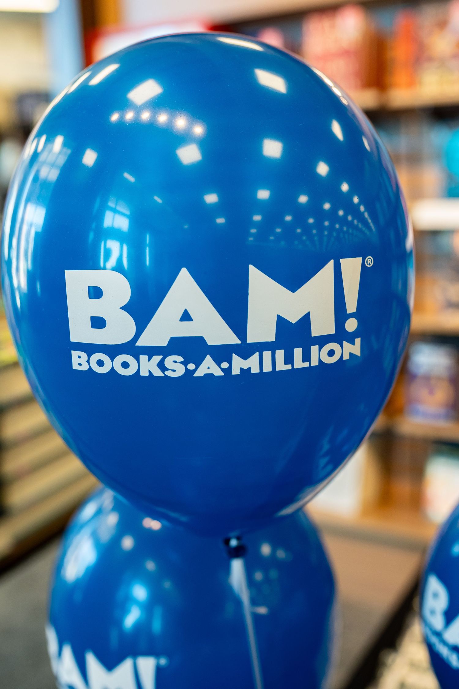Blue balloon with BAM! Books-A-Million logo floating in bookstore.