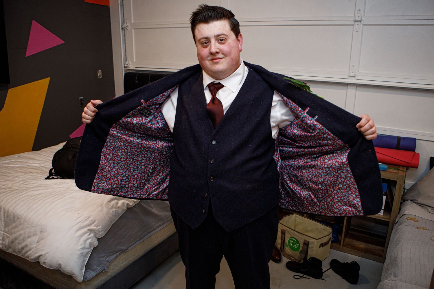 Individual showing off colorful patterned suit lining at formal event.