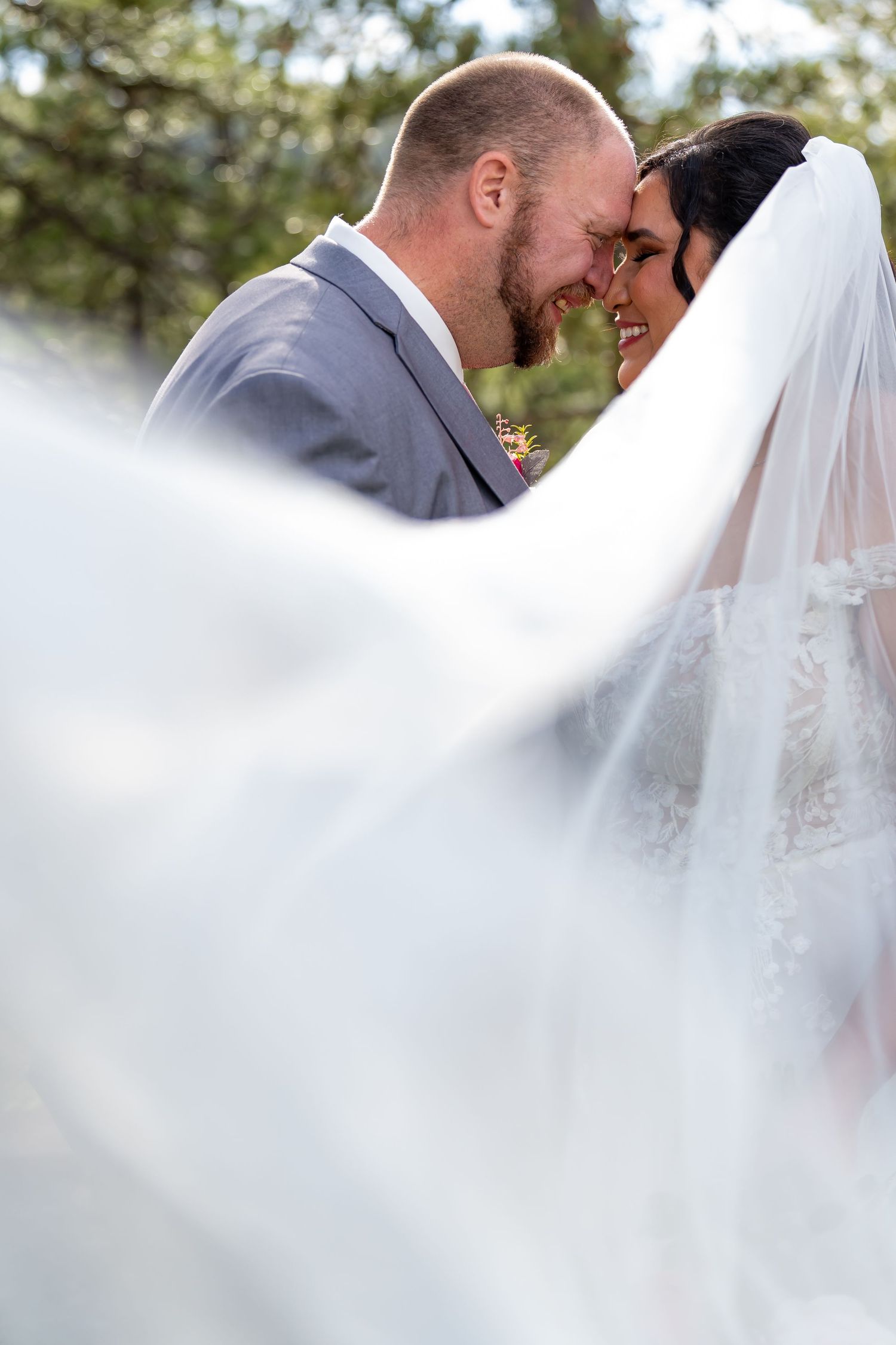 Dreamy wedding portraits with ethereal white veil creating soft romantic effect.