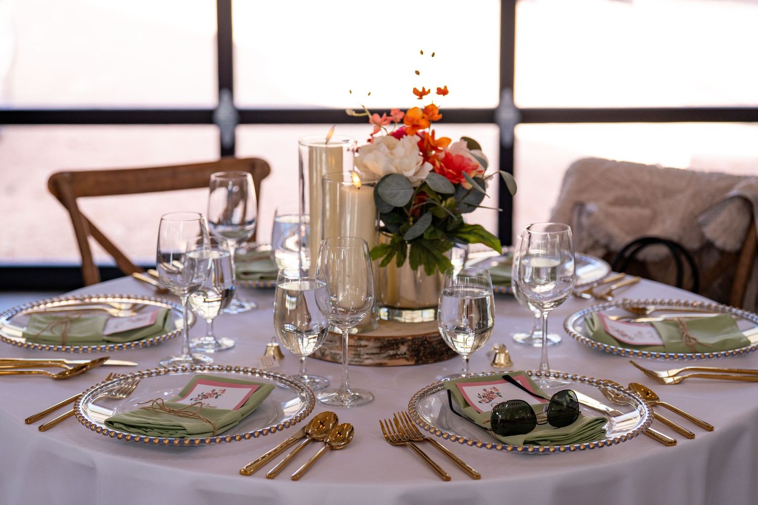 Elegant table setting with gold cutlery, beaded charger plates, and floral centerpiece at a formal event.