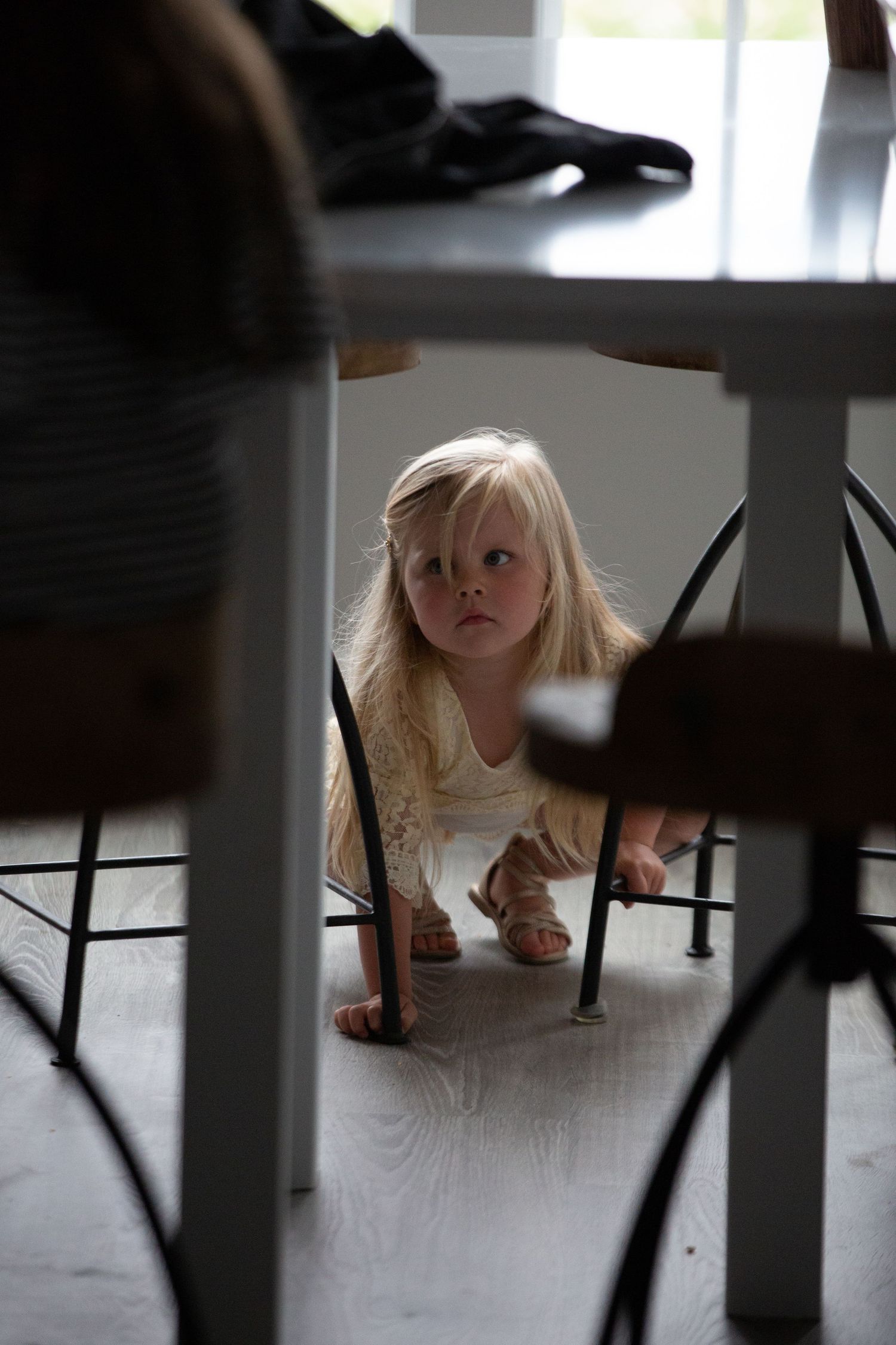 A playful series of images showing someone peeking under a table from different angles.