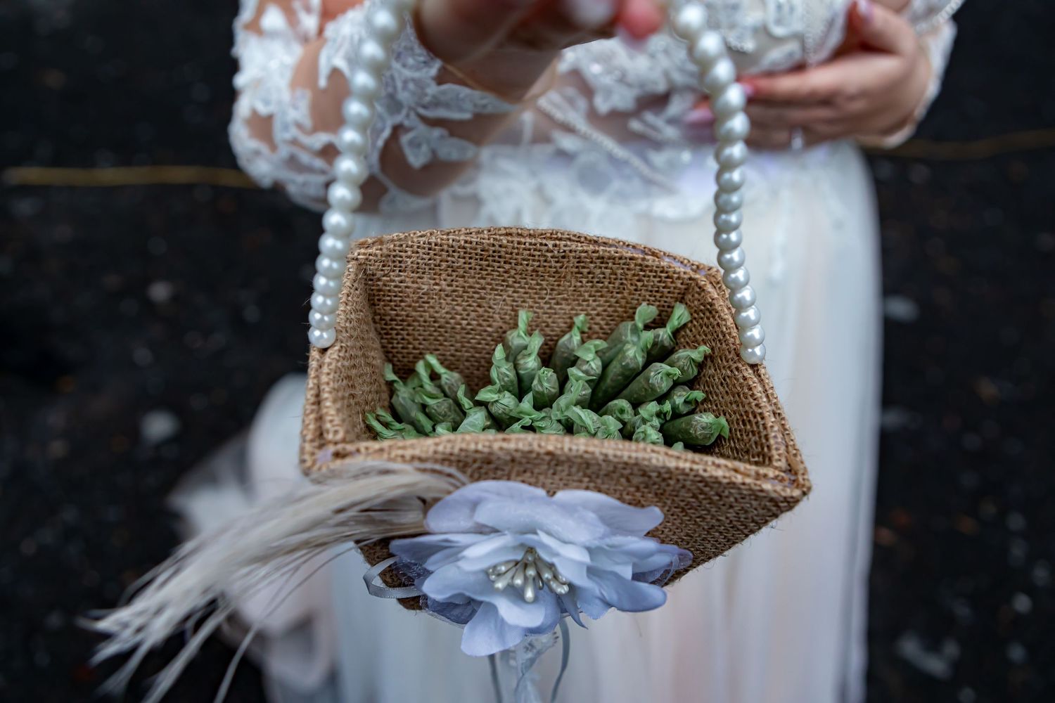 Rustic woven basket with delicate floral arrangements and feather accents.