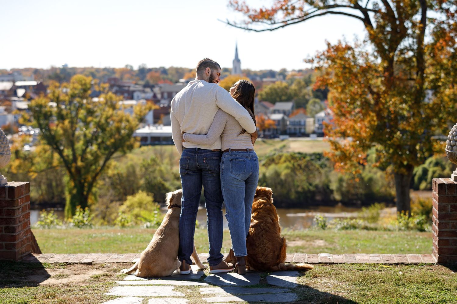 Autumn photoshoot with pets overlooking a scenic city vista.