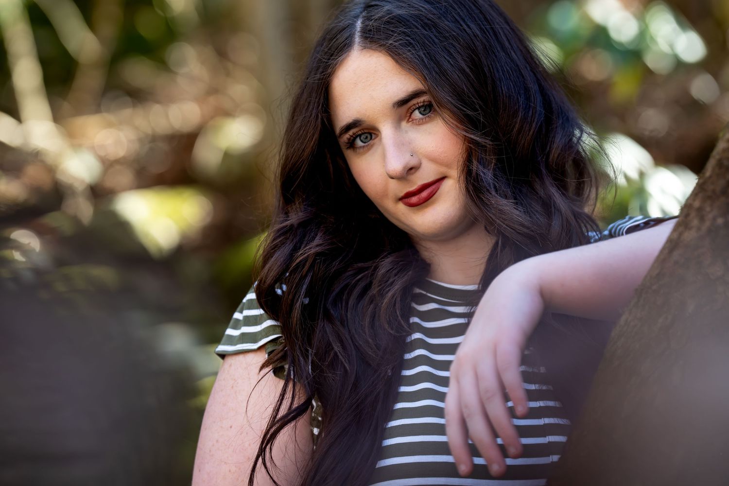 Outdoor portrait series showing relaxed poses against a natural backdrop.