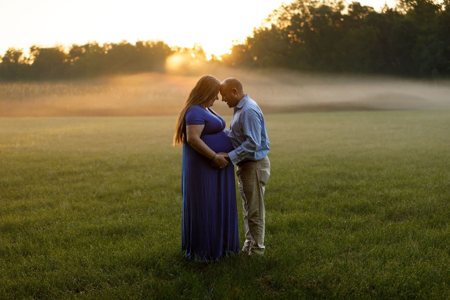 A romantic sunset engagement photo session in a grassy field.