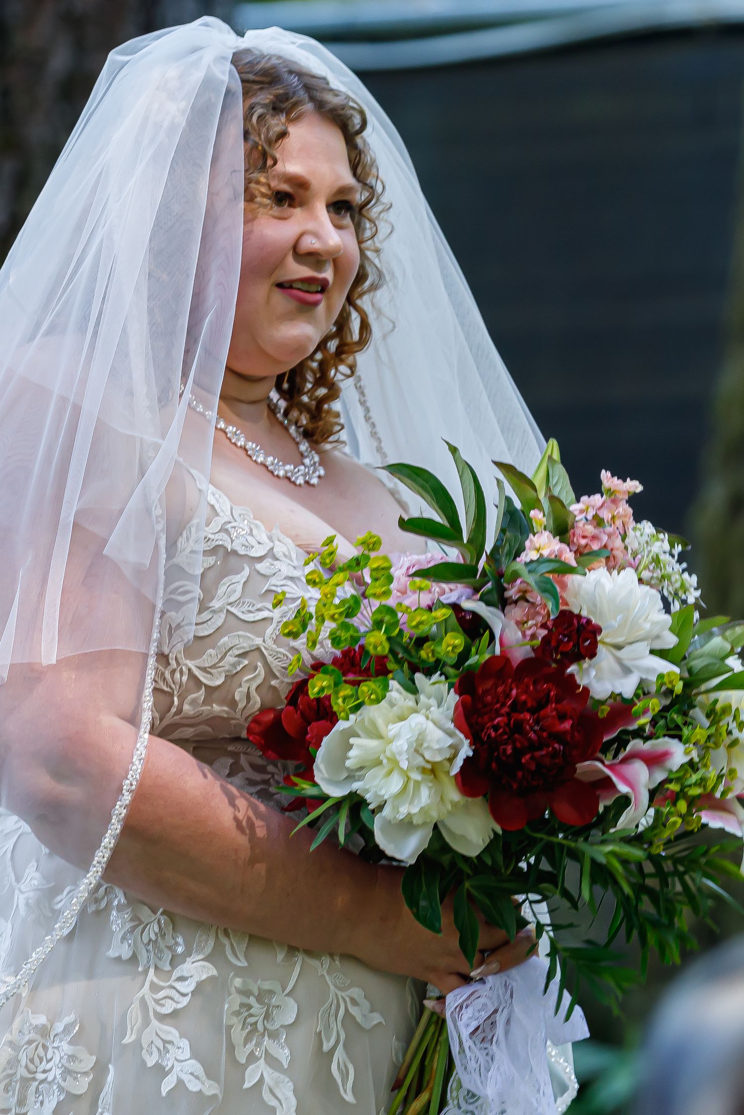 Close-up shots of a beautiful bridal bouquet featuring red and white flowers with greenery.