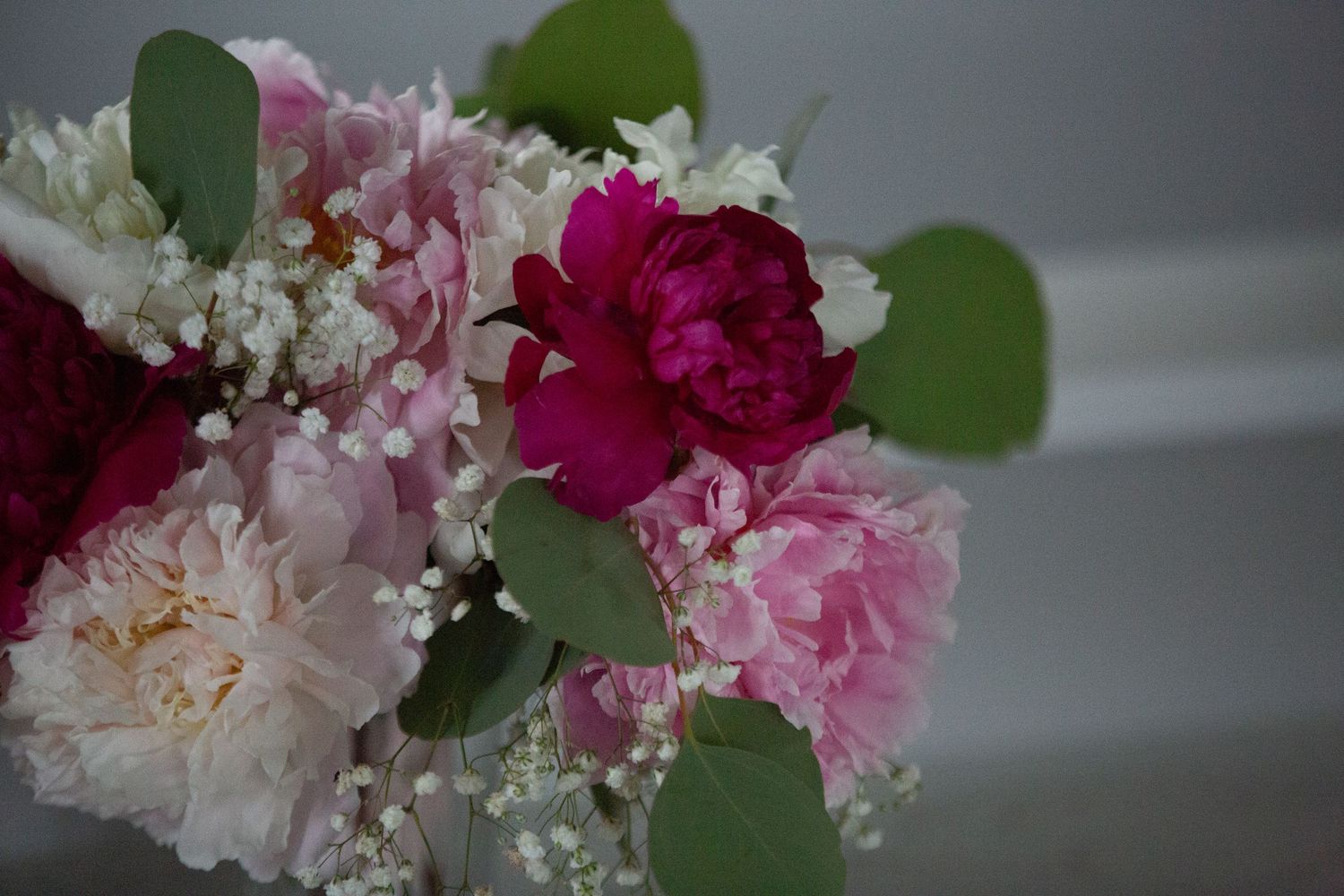 Elegant pink and white floral arrangement with green foliage.