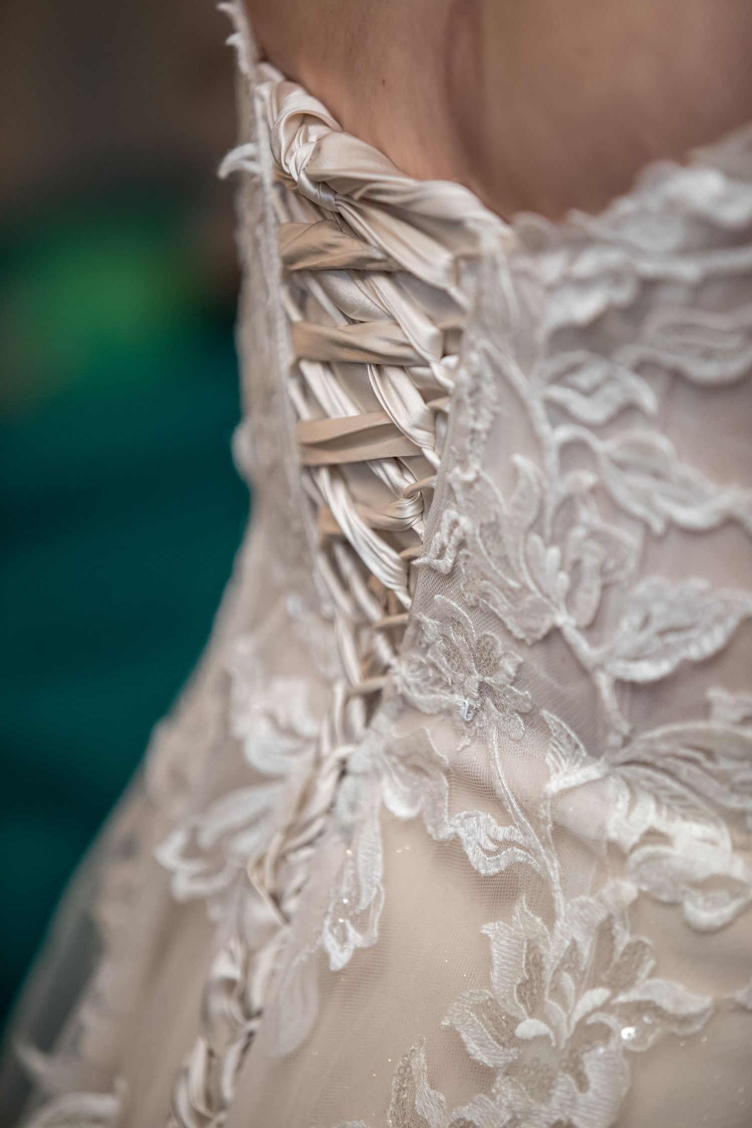 Detailed close-up of delicate lace pattern on a white wedding dress.