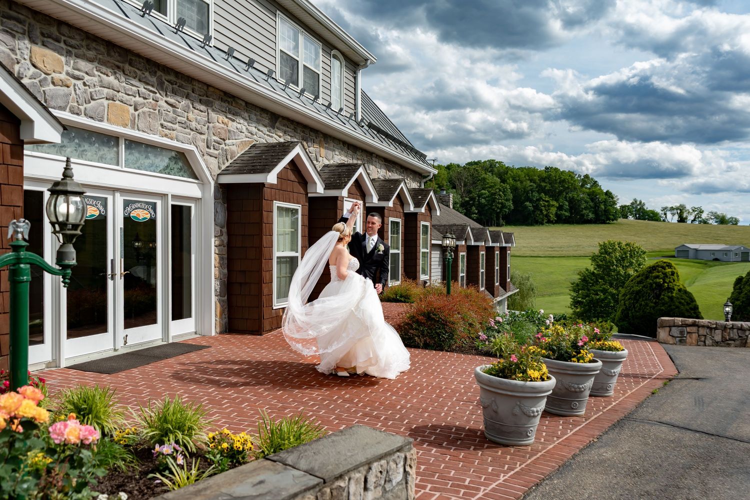Wedding venue exterior with stone facade and dramatic cloudy sky backdrop.