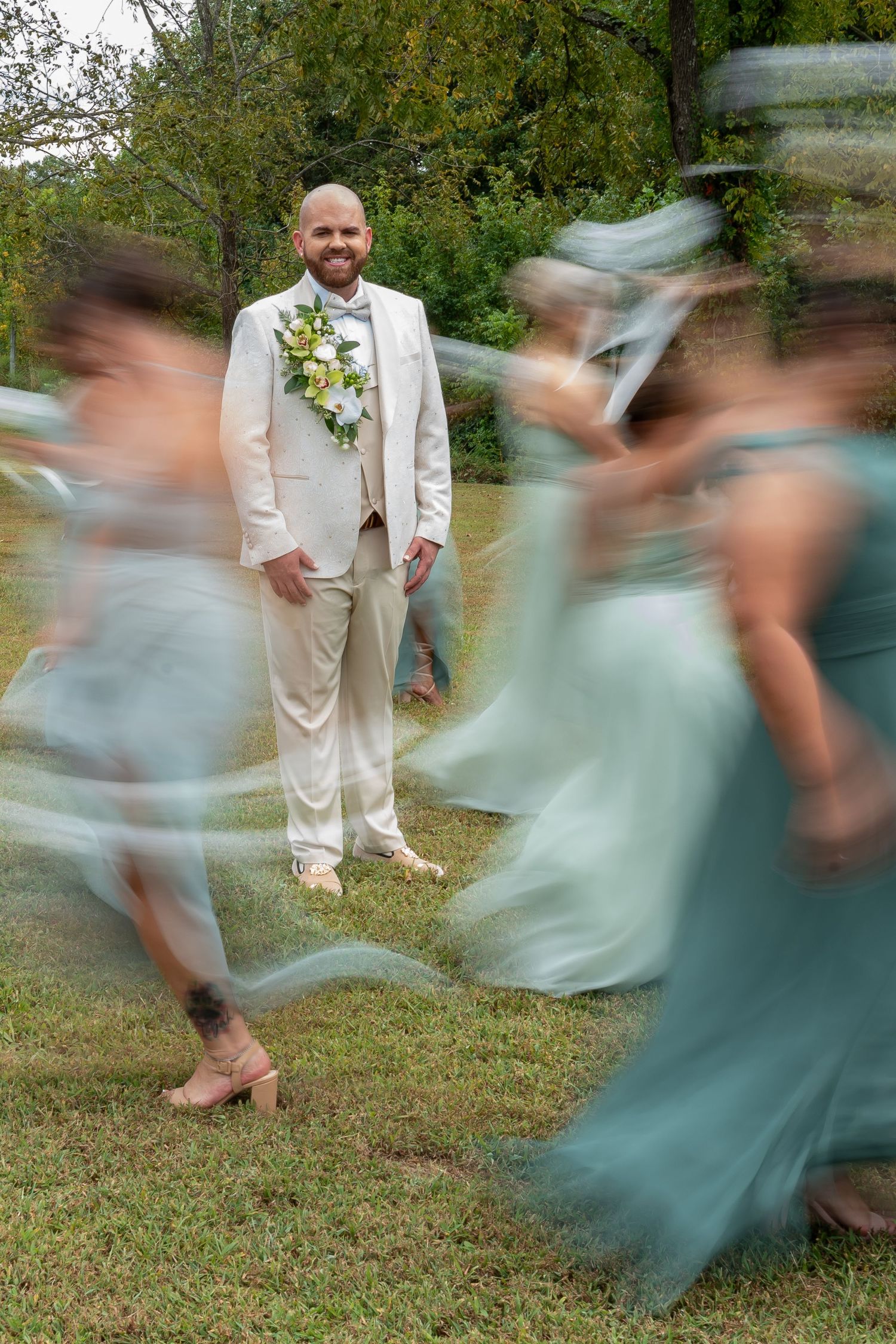 Motion blur photography captures dancers in seafoam green dresses twirling outdoors.