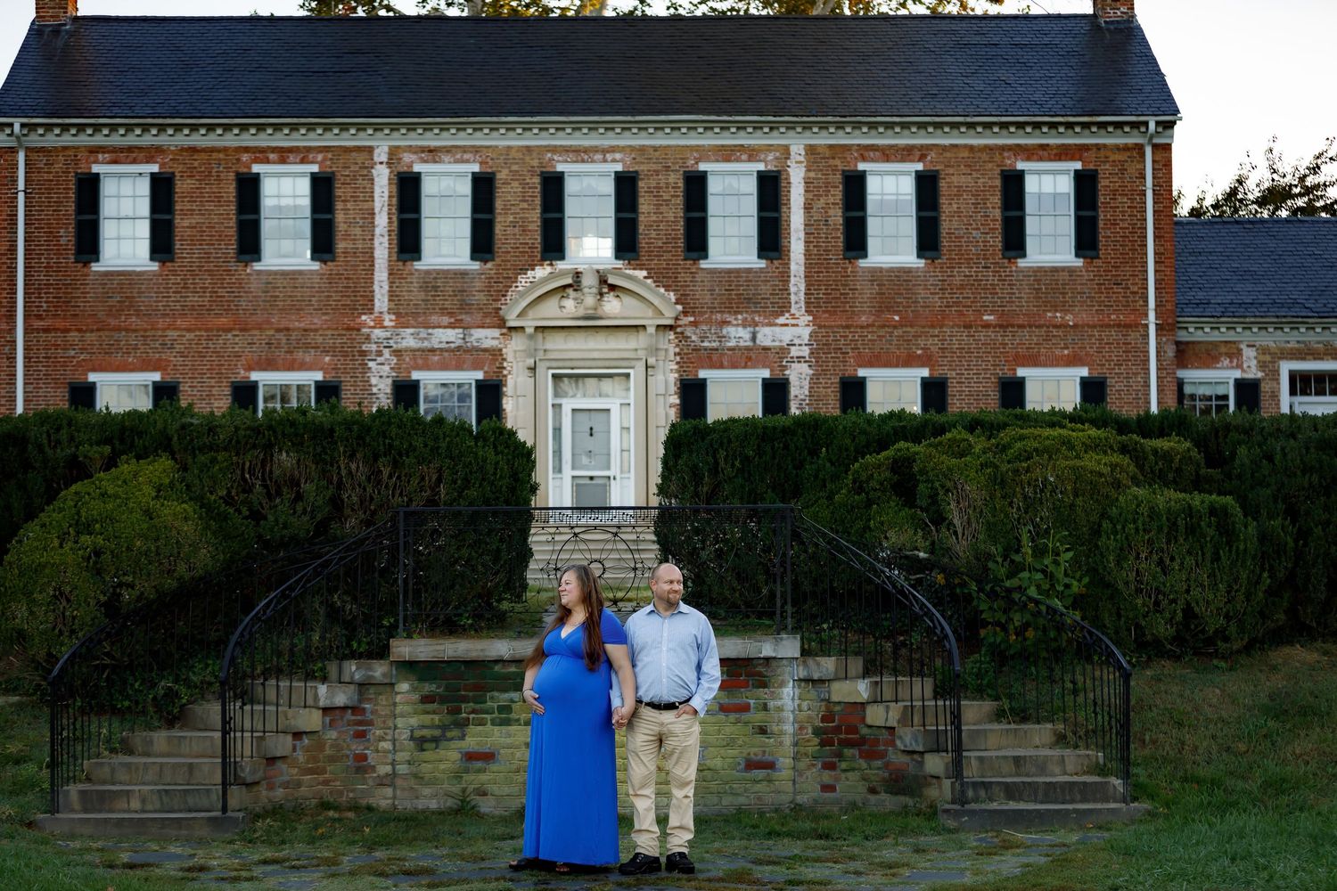 Scenic outdoor portrait session on stone steps of a stately brick building.