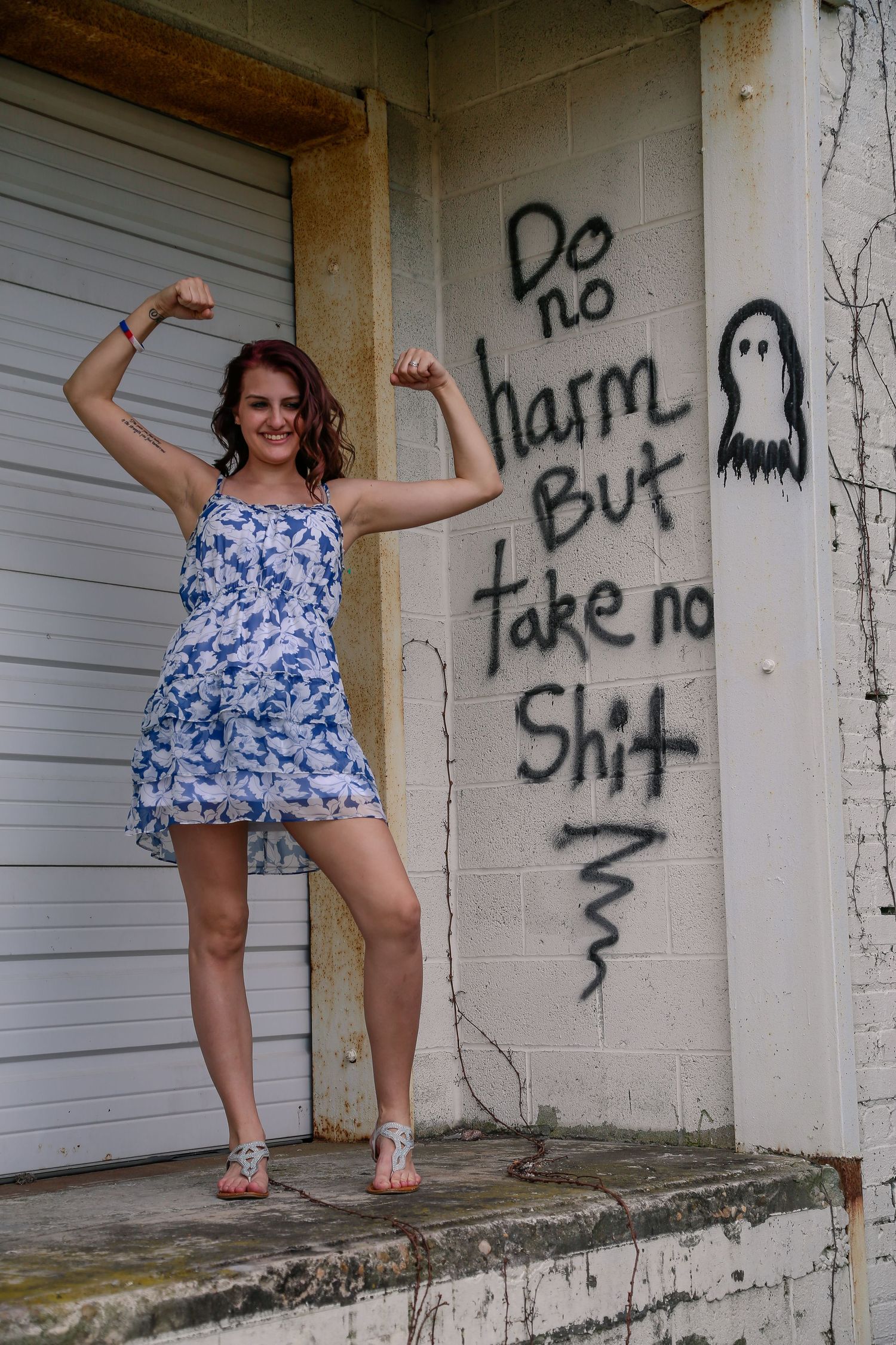 Playful fashion poses against white garage doors with graffiti text.