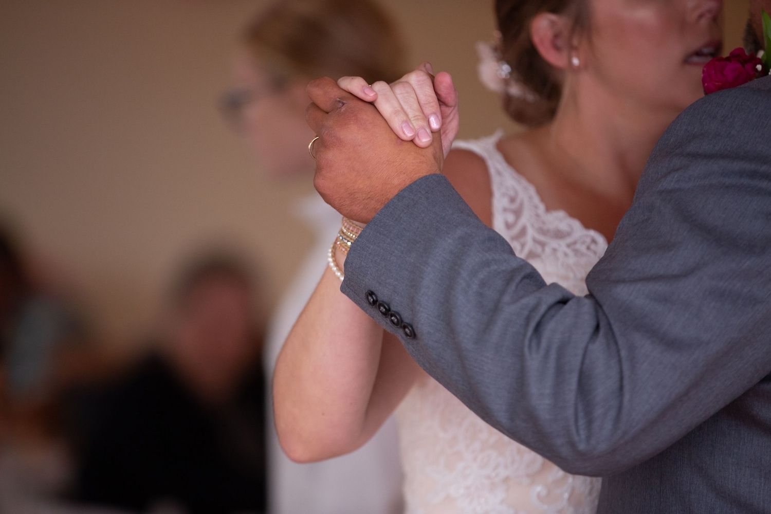Elegant couple sharing a romantic slow dance at a wedding reception celebration.