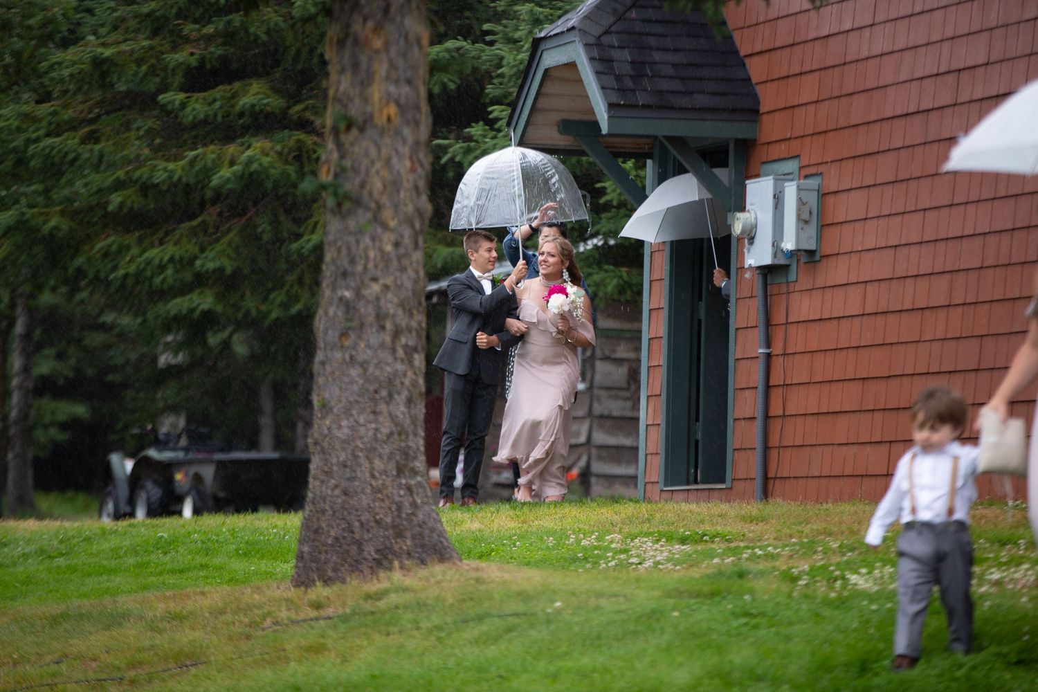 Group gathering outside a brick building with cedar shingles on an overcast day.