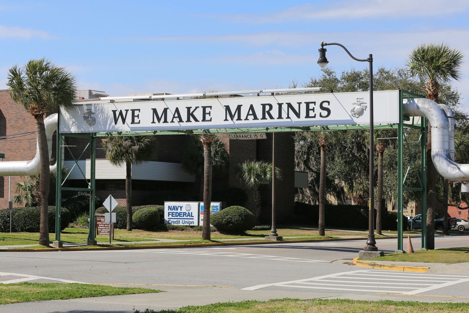 Entrance gate with 'WE MAKE MARINES' sign at Marine Corps training facility.