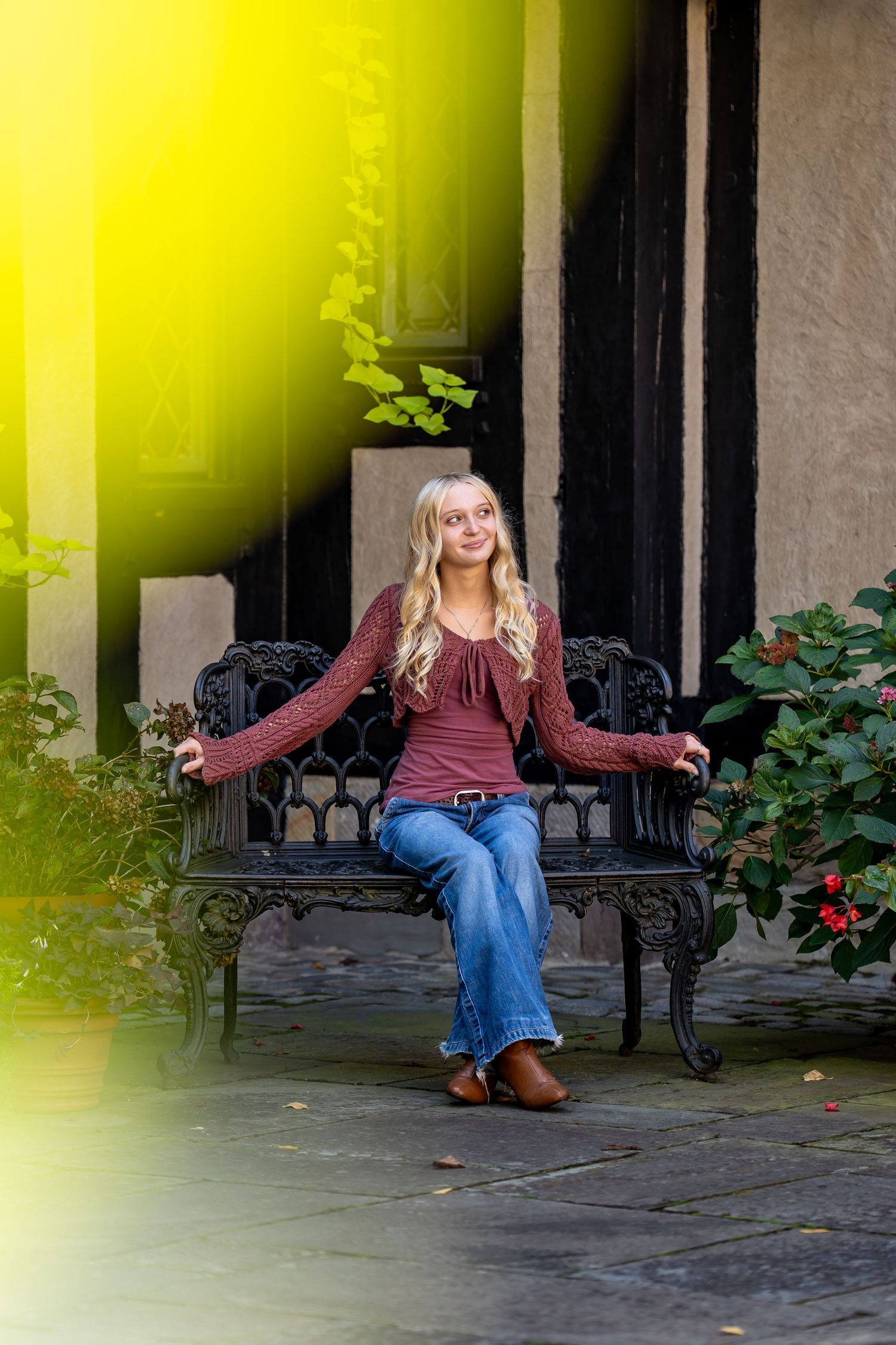 Portrait session on decorative bench with yellow lighting effects.