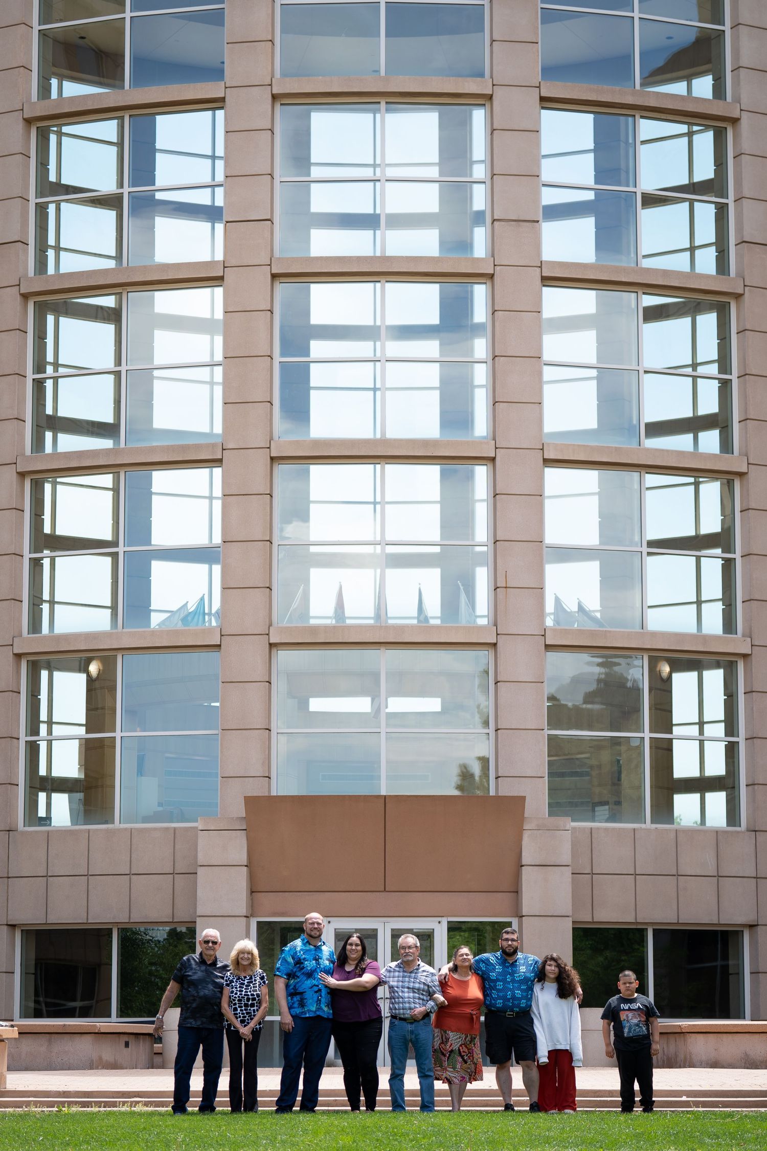 A modern glass office building facade with curved windows and beige stone exterior.