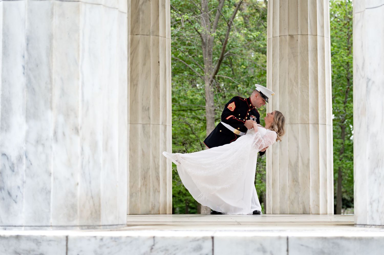 Romantic wedding dance between marble columns with flowing white dress.