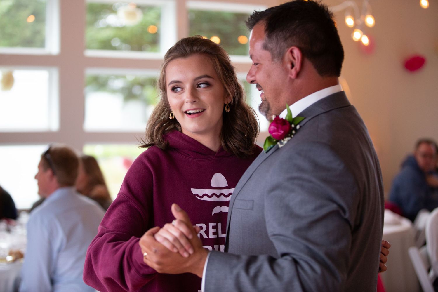 Wedding couple sharing special moments with guests in a reception hall with purple accents.
