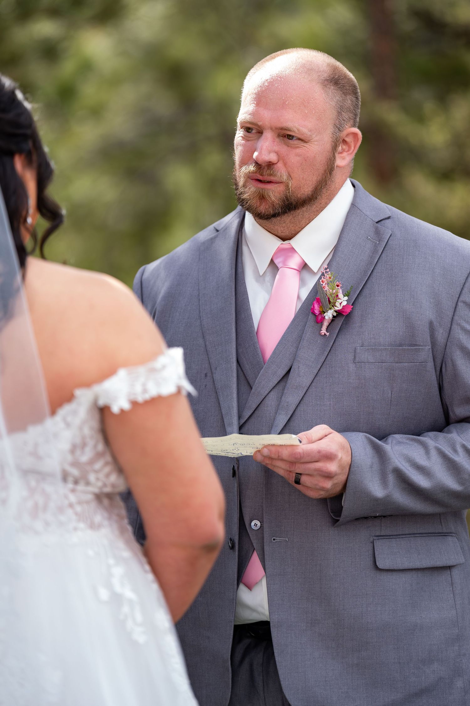 Exchange of vows between couple during outdoor garden wedding ceremony.