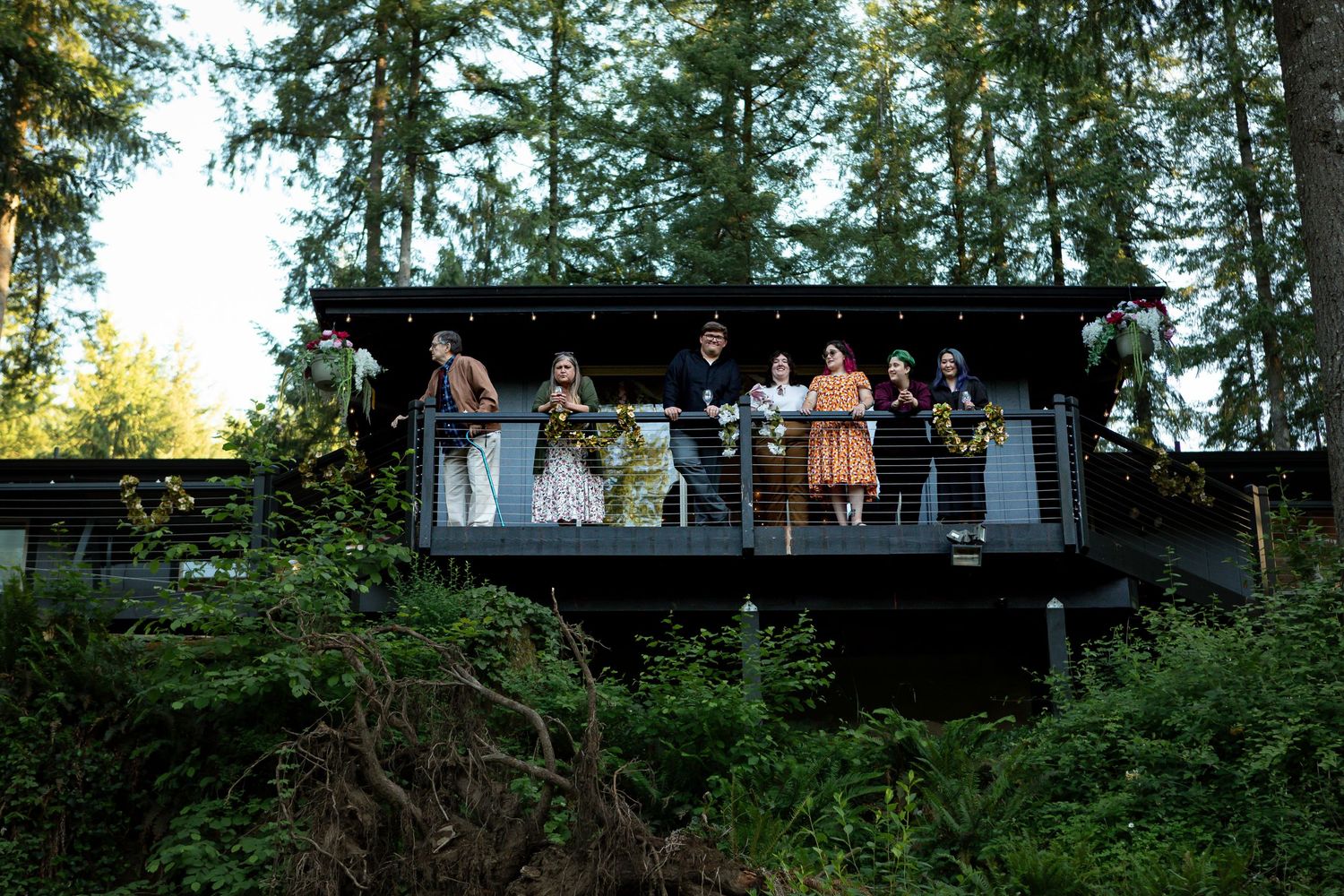 Long view of guests on elevated deck surrounded by tall trees.