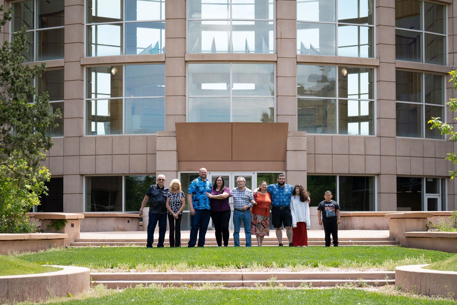 A group of people standing in front of a modern glass office building.