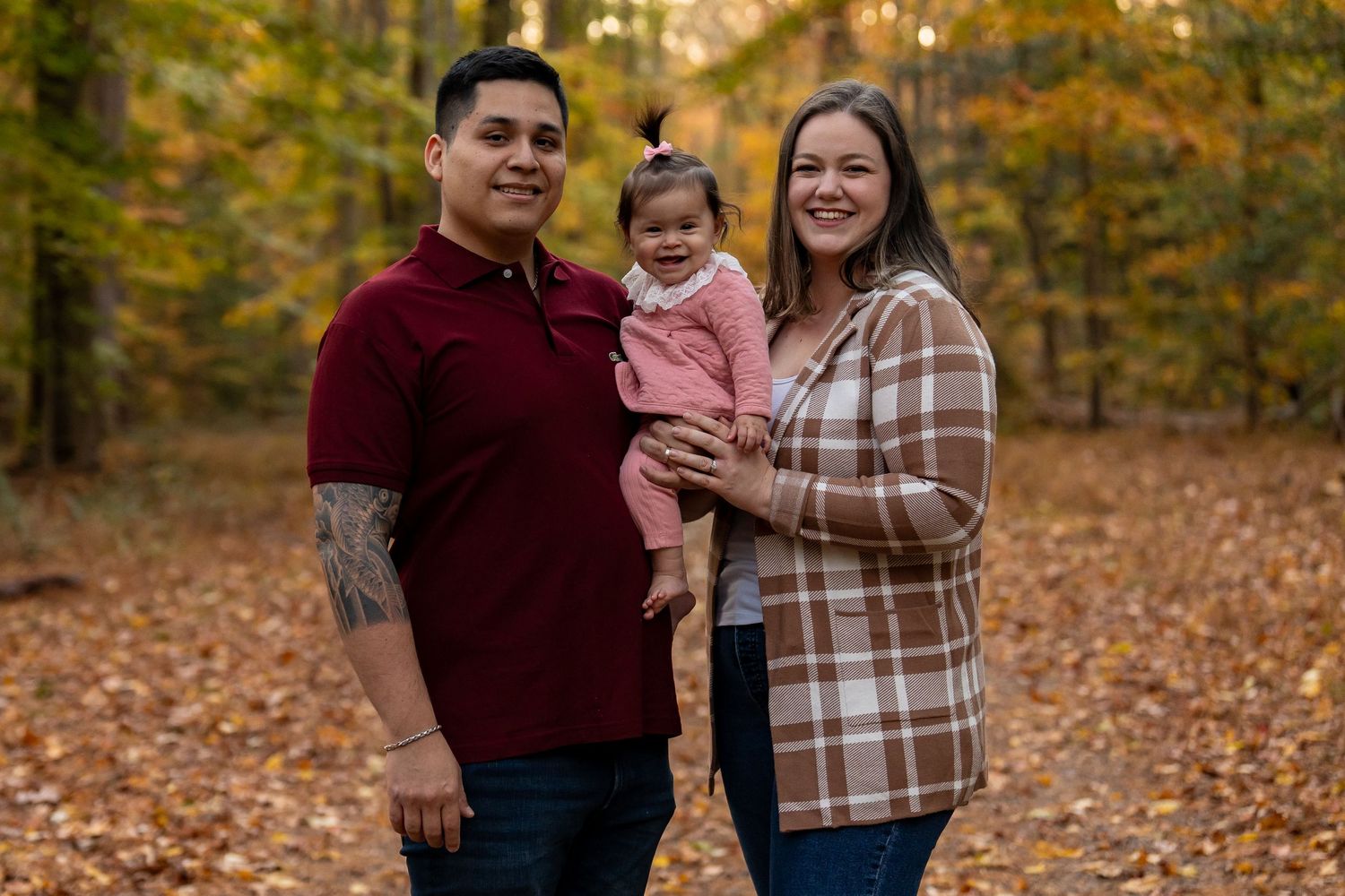 A family enjoying an autumn day in a forest with golden foliage.