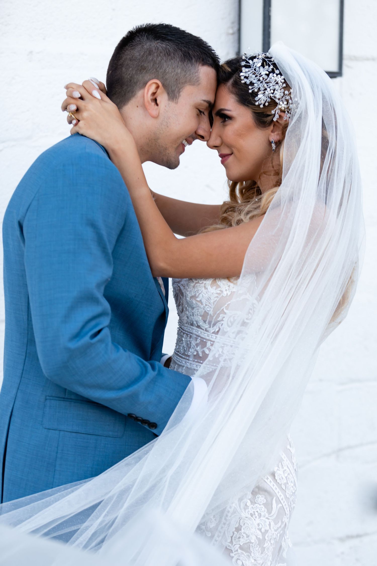 Romantic wedding portraits against white architectural backdrop.