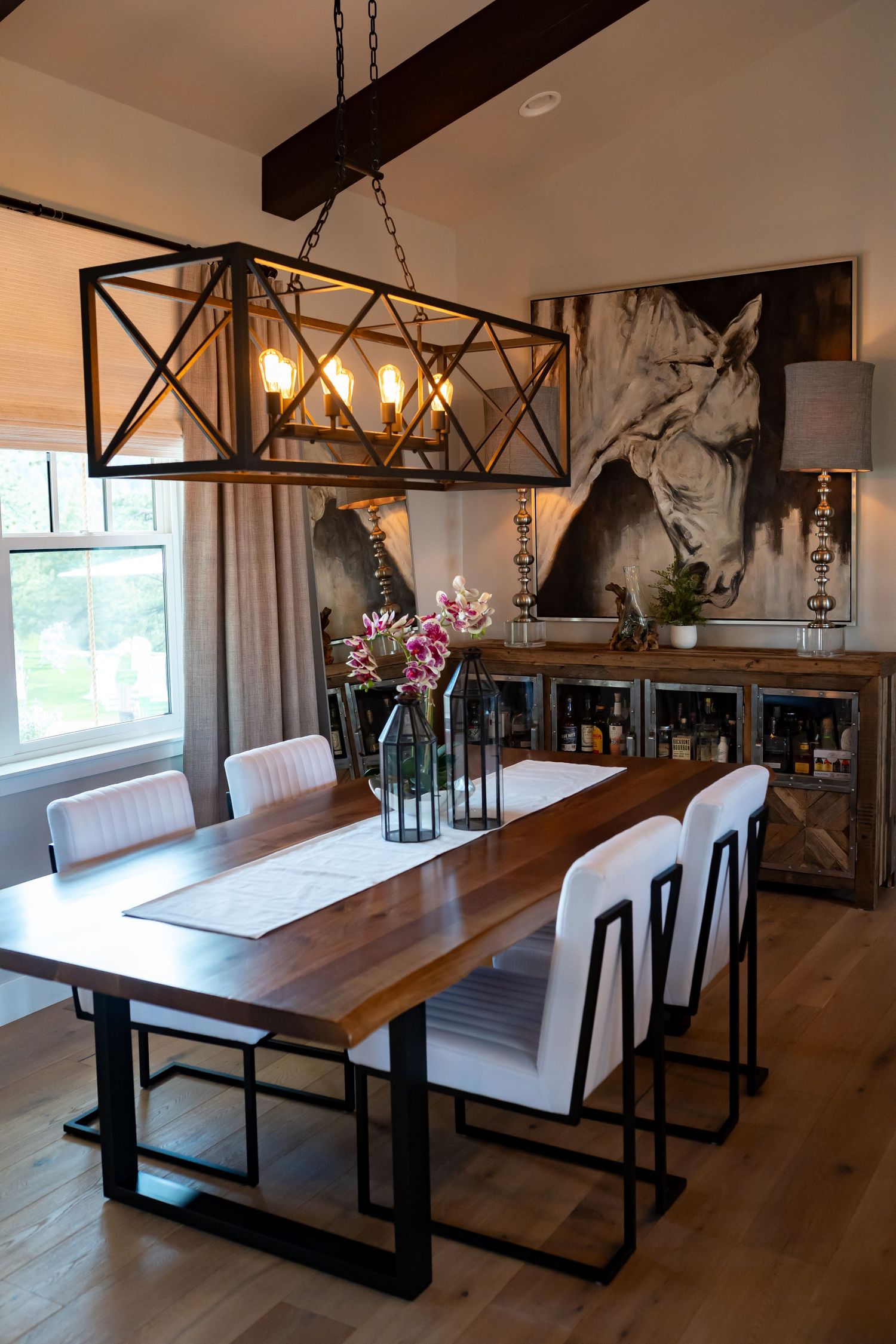 Industrial chic dining area with wooden table, white upholstered benches and metal accents.