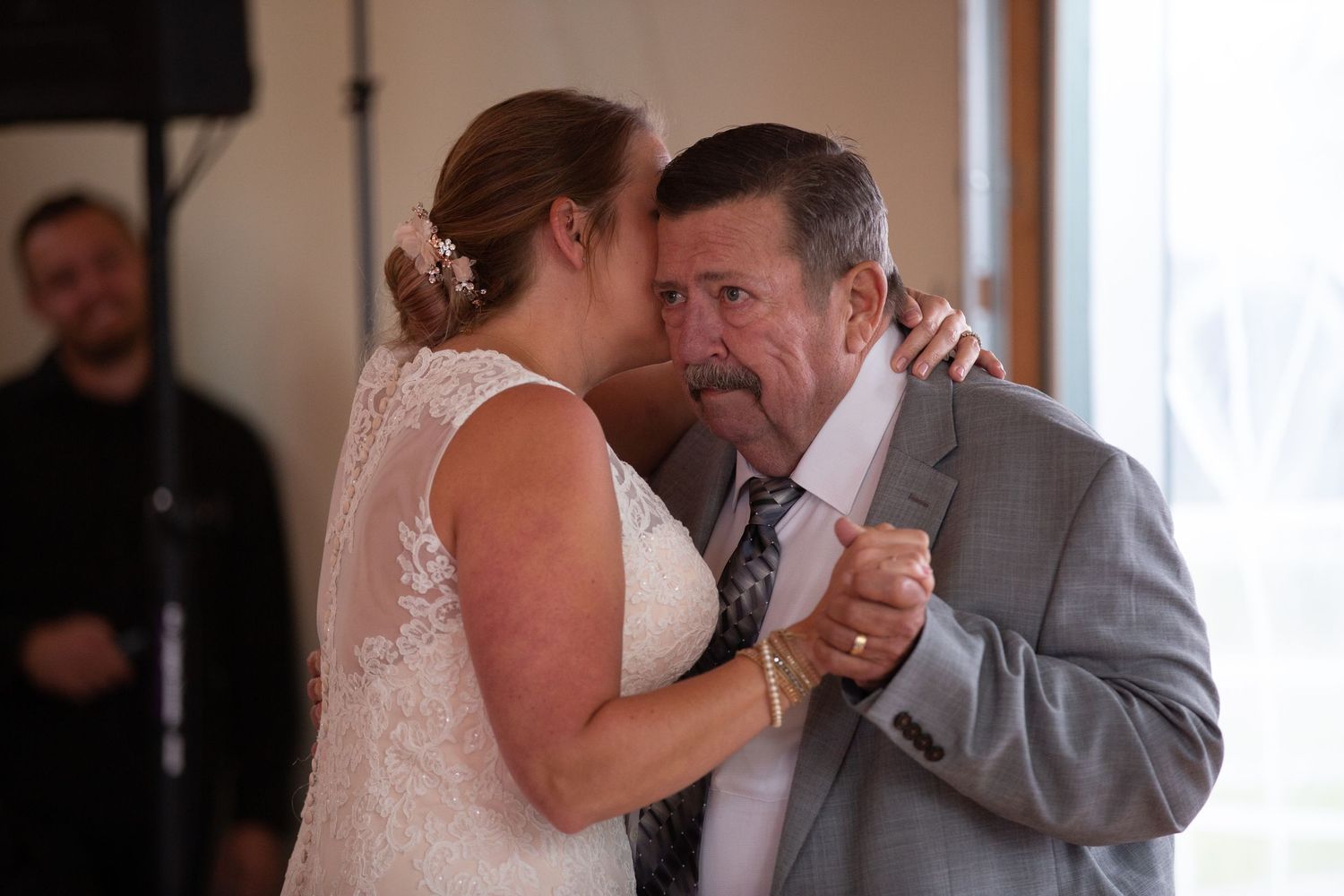 A tender dance moment at an indoor wedding reception.