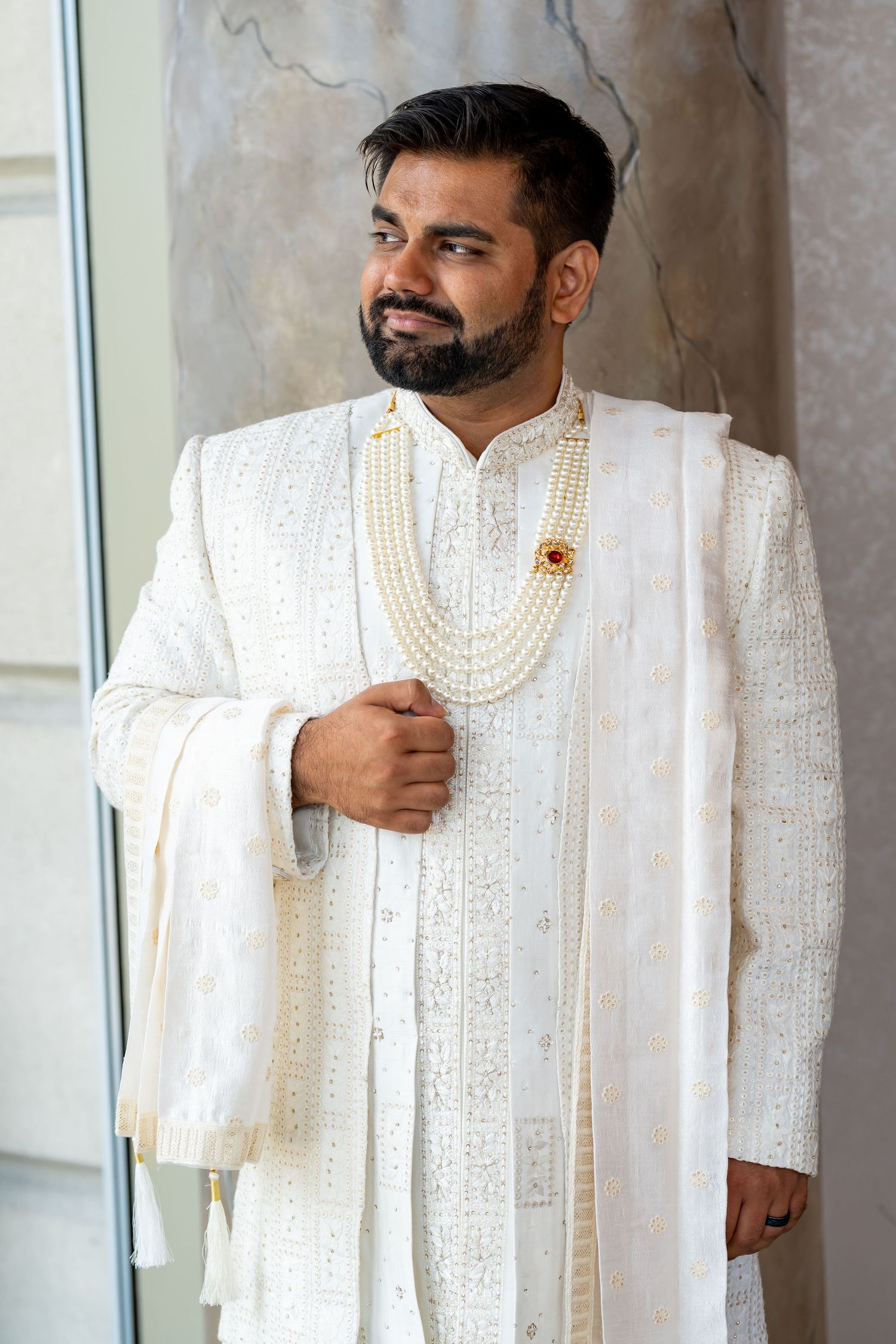 White embroidered sherwani with pearl details photographed in sequence.