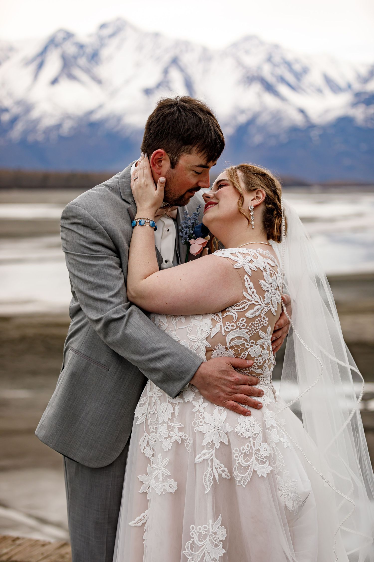 A tender moment between newlyweds with snow-capped mountains in the background.